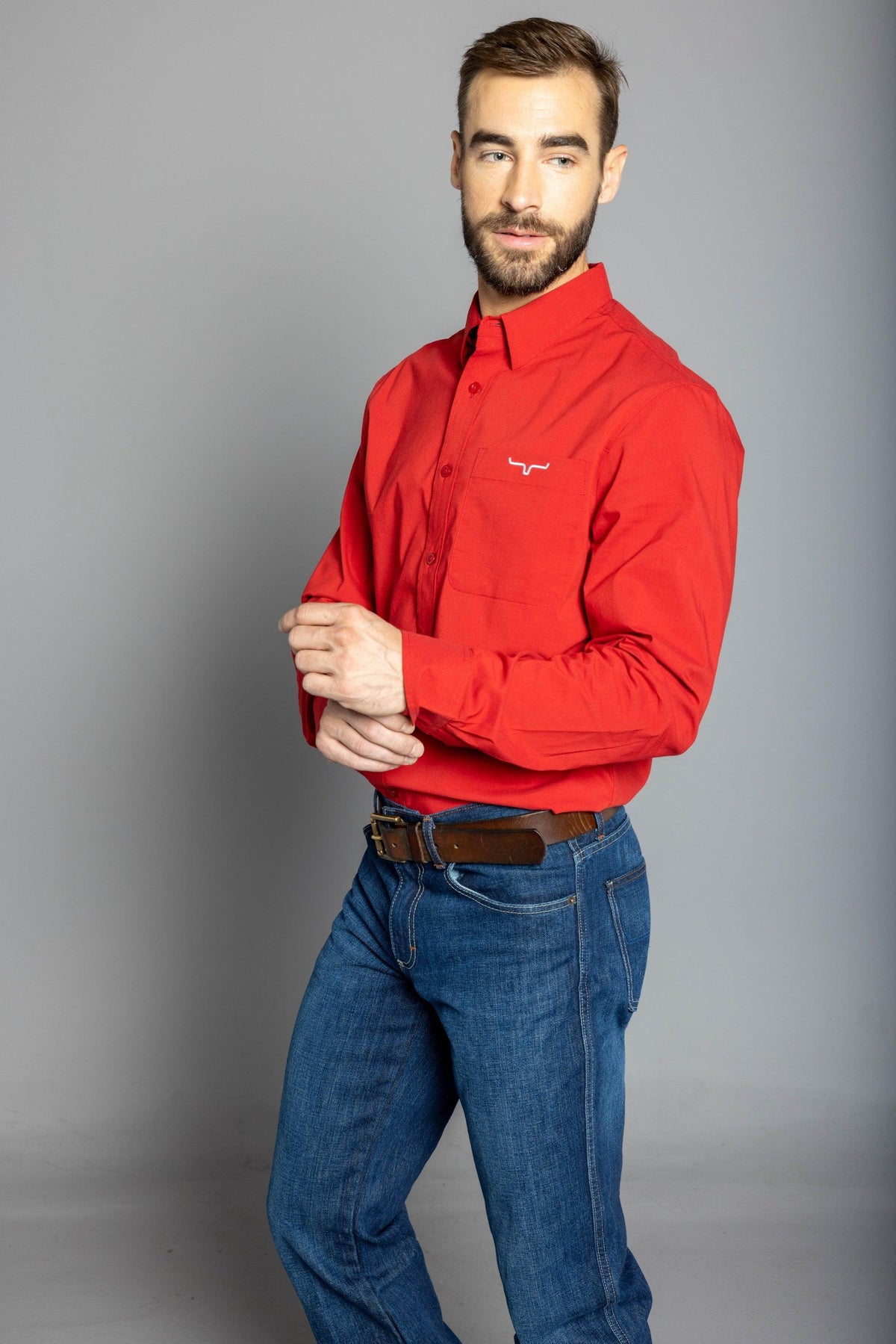 Kimes Ranch KR Team Dress Shirt in Red, side view, with long sleeves and a chest pocket with the Kimes Ranch logo