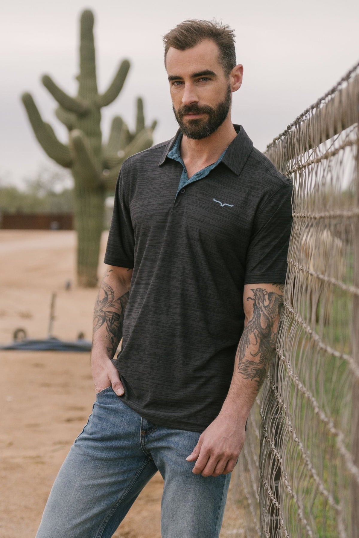Kimes Ranch Fletcher polo in Black with a contrasting blue collar and a small white logo on the chest