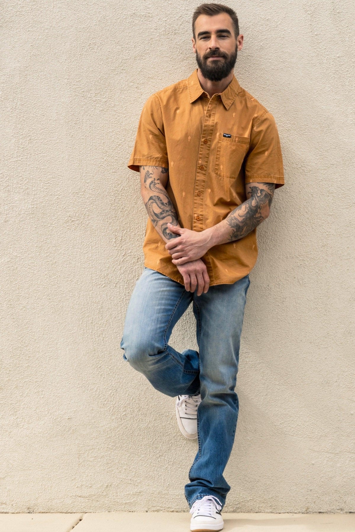 Kimes Ranch Barney Slim Fit Bootcut jeans in blue with a model wearing a mustard shirt