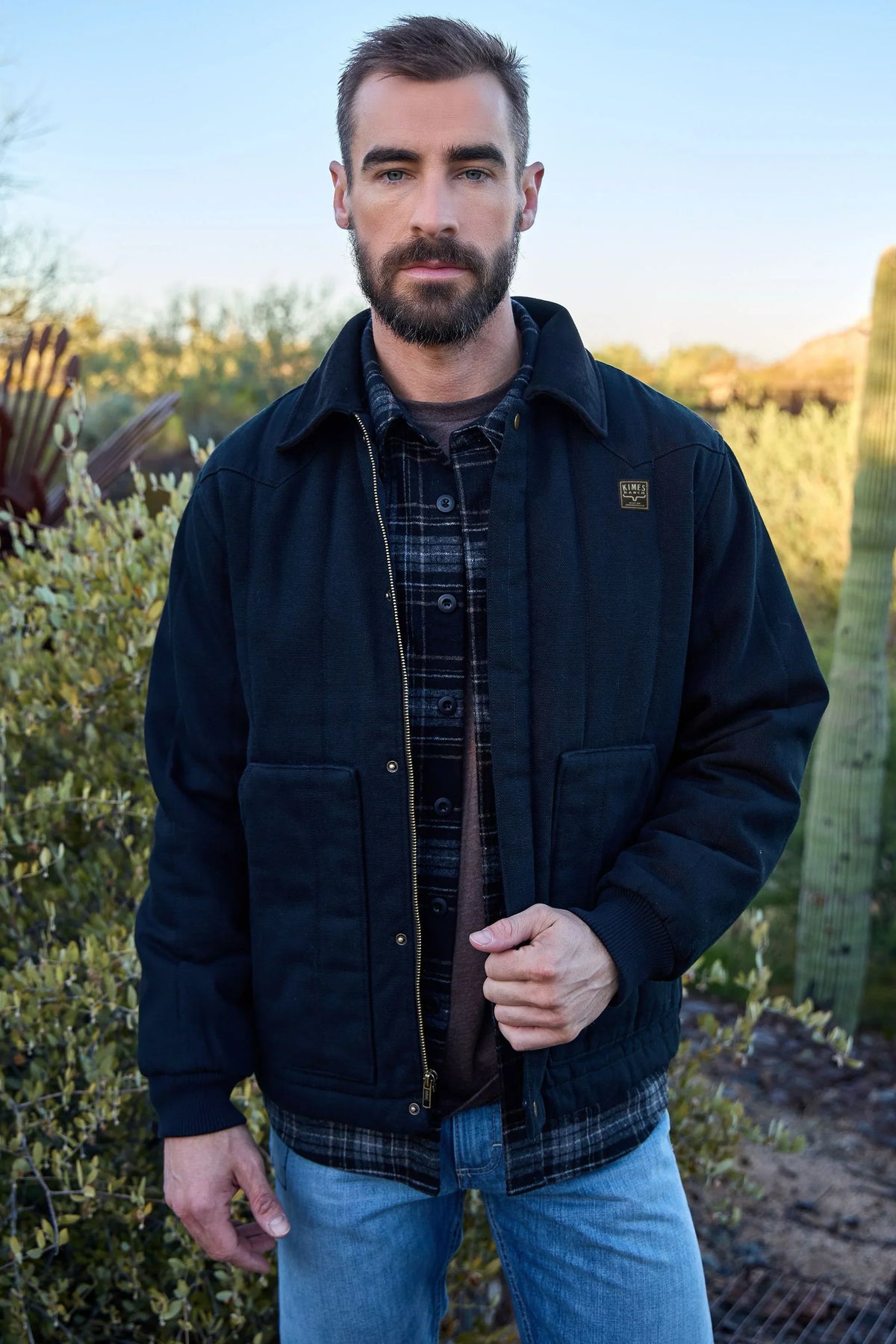 Kimes Ranch Lewiston Jacket in Black with a collar, front pockets, and the Kimes Ranch logo on the chest