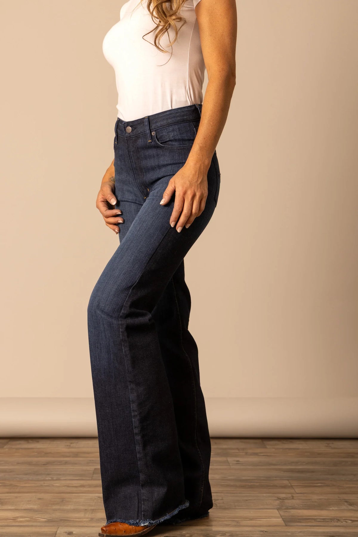 Kimes Ranch Olivia jeans in Dark Wash, side view, with a flared leg and raw hem