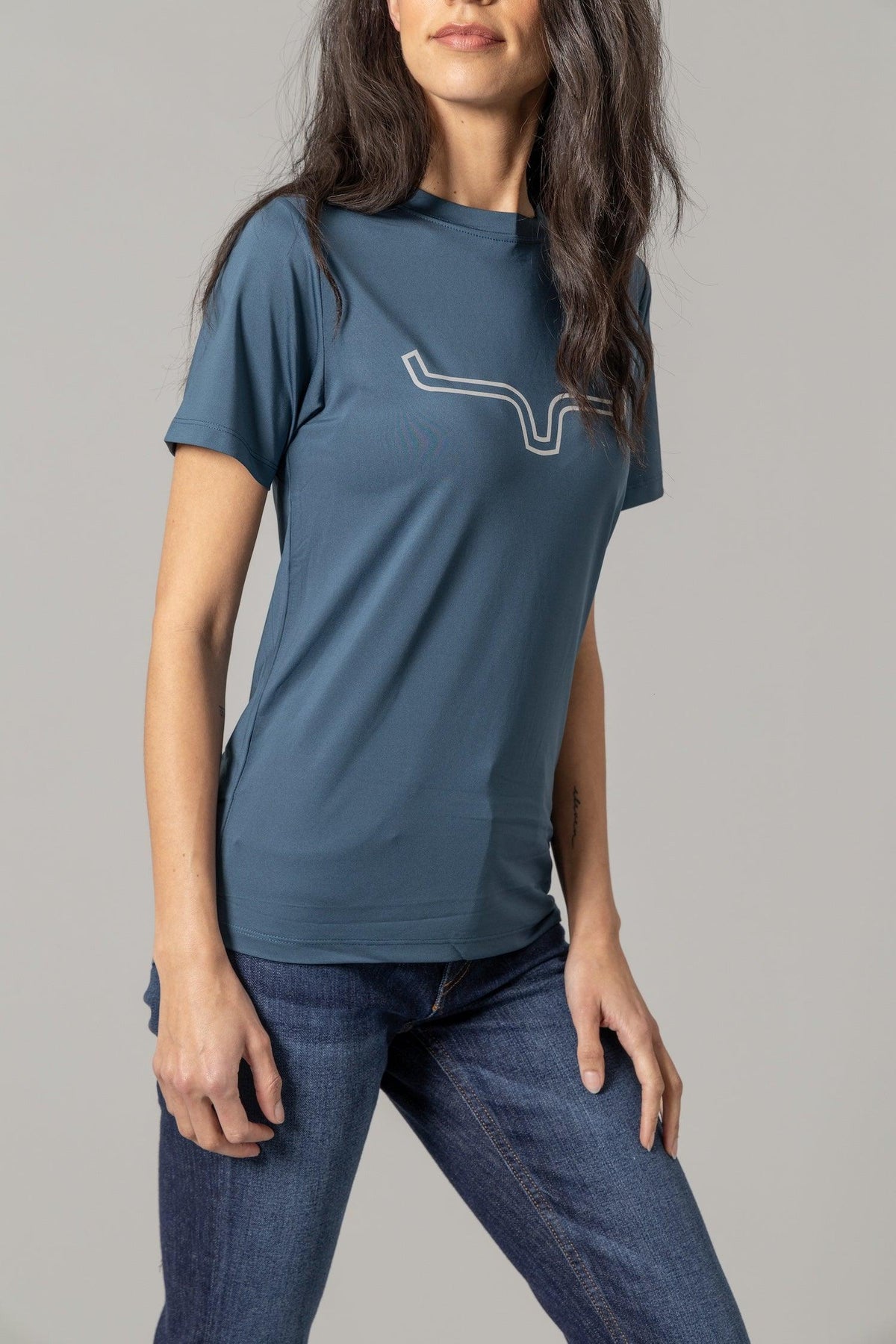 Kimes Ranch Ladies Outlier Tech Tee Shirt in Major Blue, side view, with a white outline steer logo on the chest