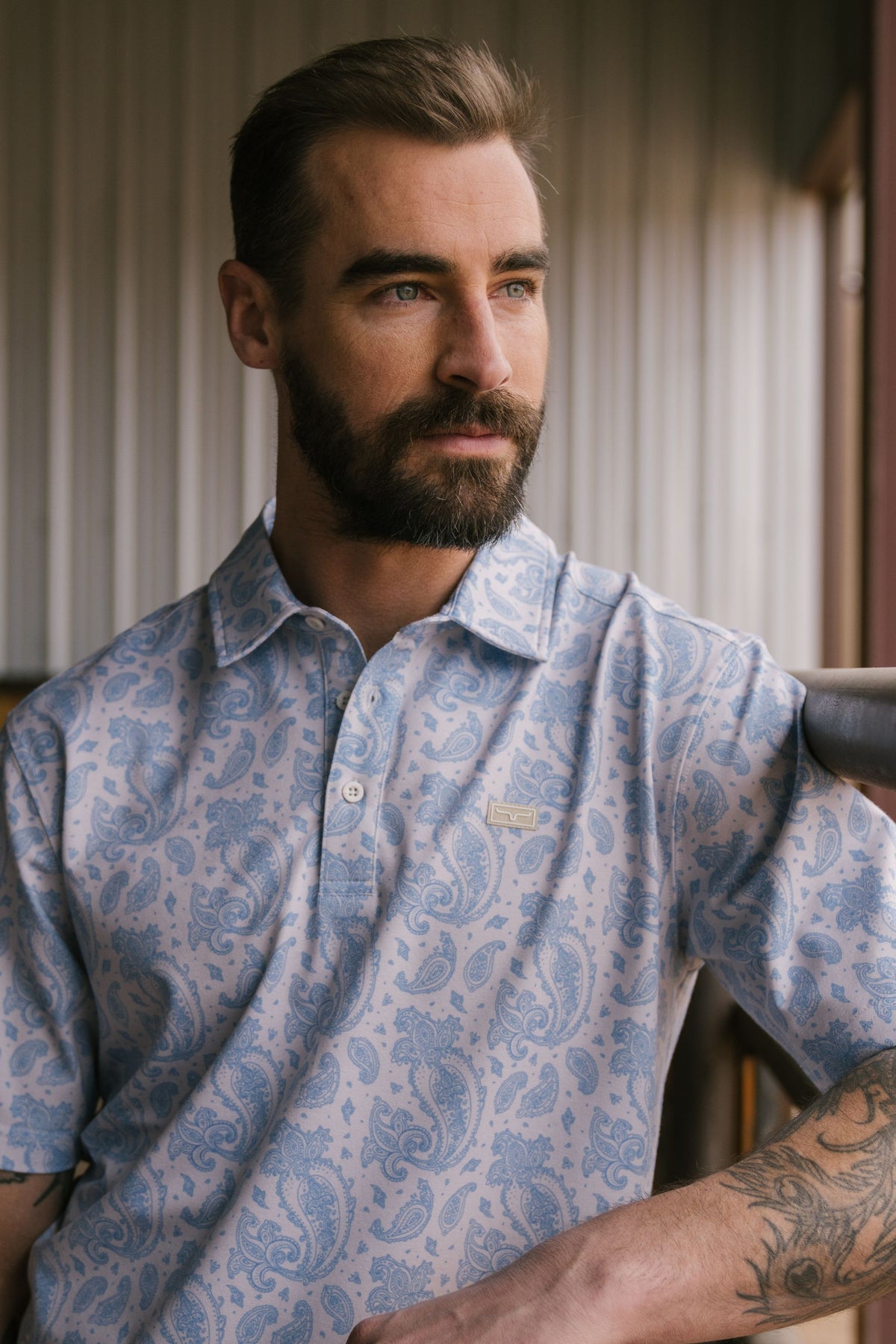 Kimes Ranch Burel polo in Blue with a paisley print and a Kimes Ranch logo on the chest