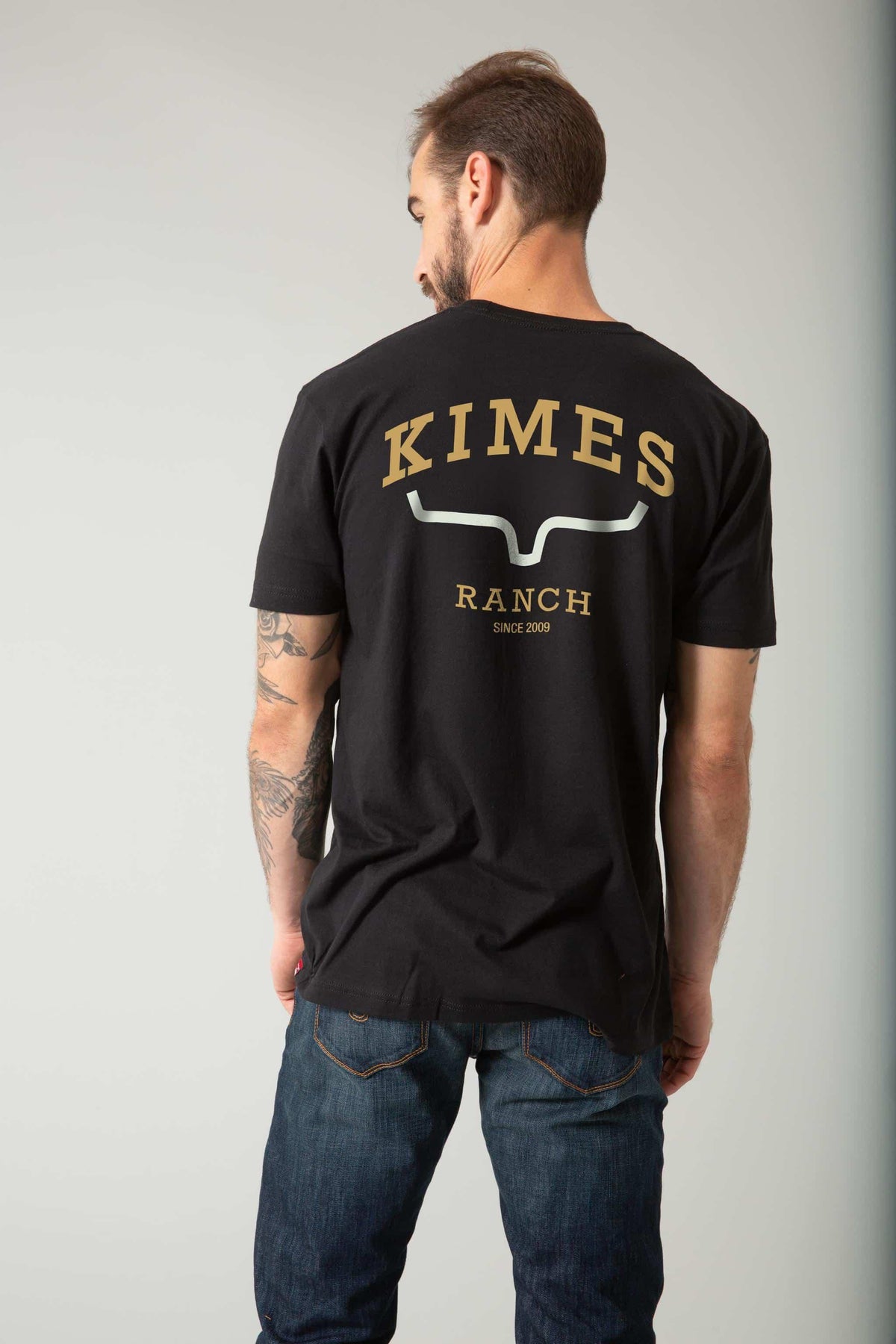 Kimes Ranch Since 2009 Shirt in Black, back view, with gold KIMES RANCH text and silver logo on the back