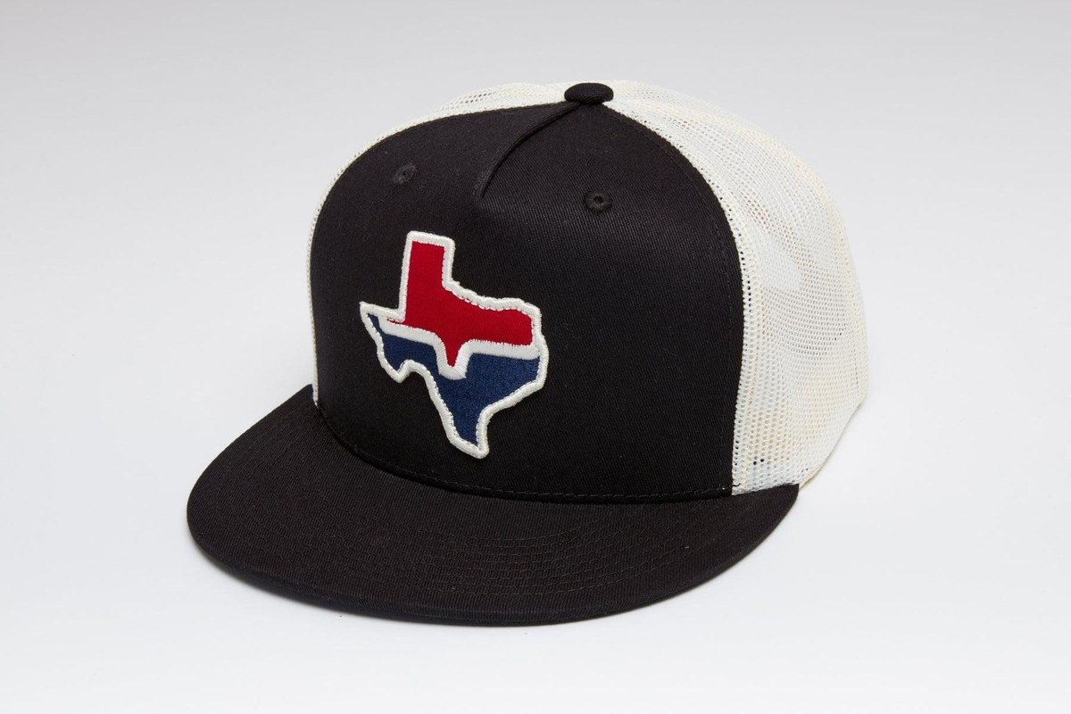 Kimes Ranch Texas Trucker Hat in Black with a red, white, and blue Texas state outline patch on the front