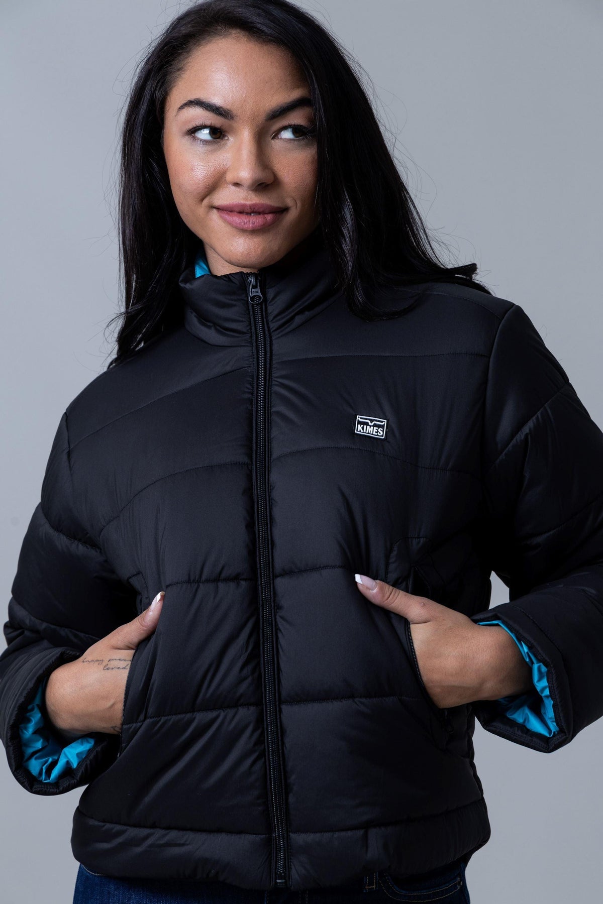 Kimes Ranch Valencia Puffy jacket in Black with a high collar, front zip, and teal lining