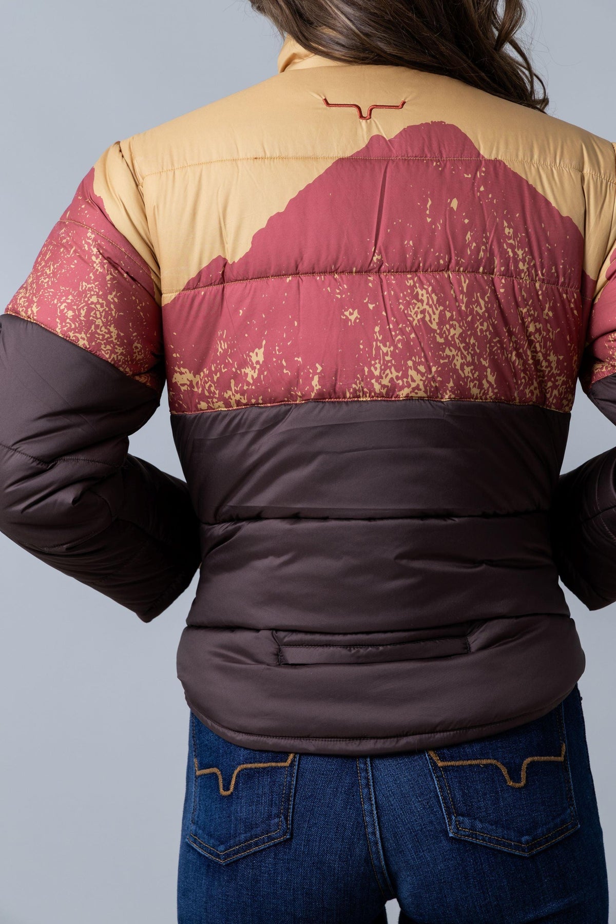 Kimes Ranch Valencia Puffy, back view, jacket back with Gold and burgundy mountain graphic and Kimes Ranch logo
