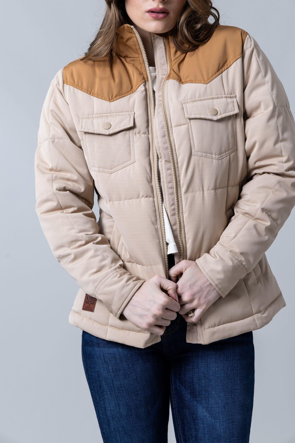 Kimes Ranch Wyldfire Jacket in Tan with a quilted body, snap flap pockets, and a contrasting yoke