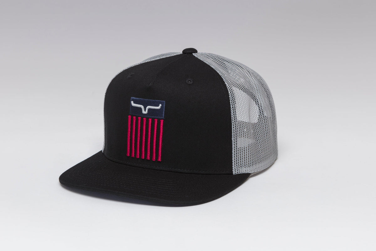 Kimes Ranch Cody Trucker hat in Black, side view, with a red and blue logo patch and grey mesh back