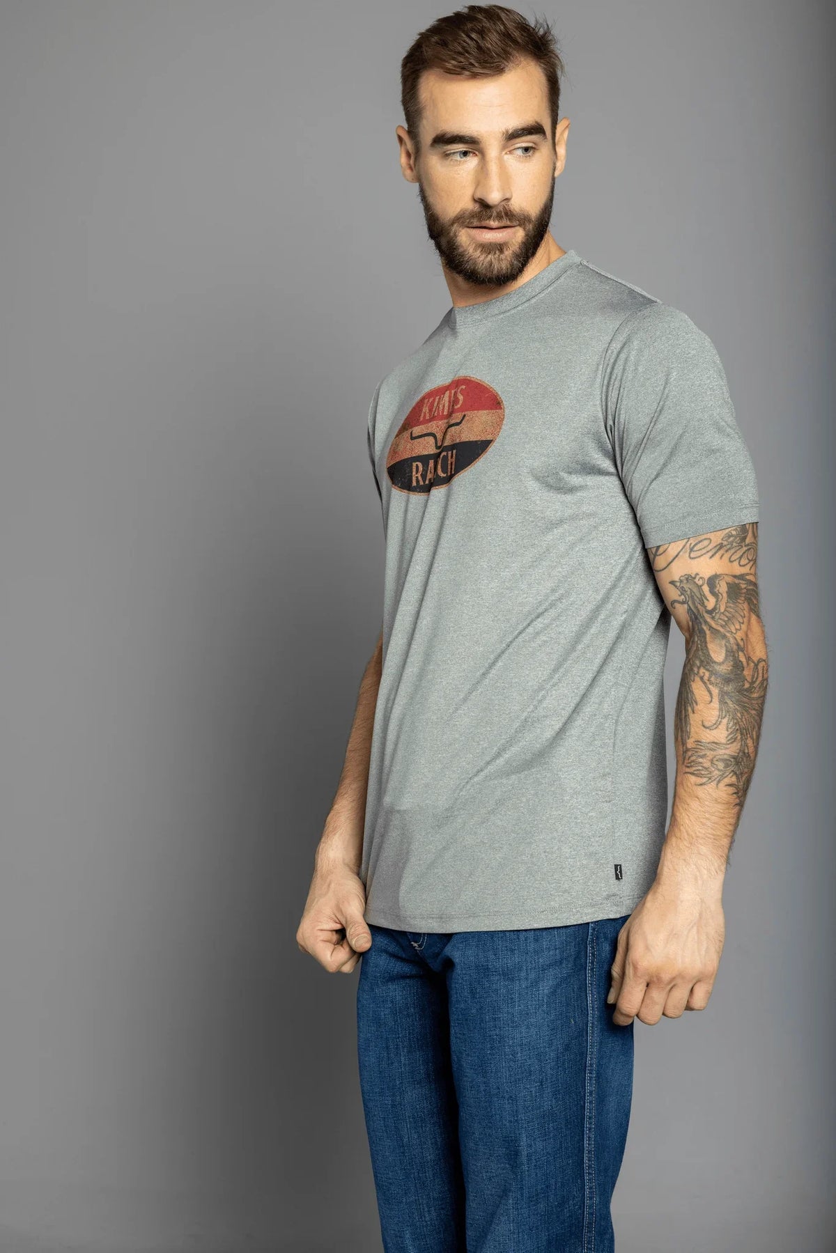 Kimes Ranch American Standard Tech T-Shirt in Athletic Grey Heather, side view, with vintage oval graphic and logo
