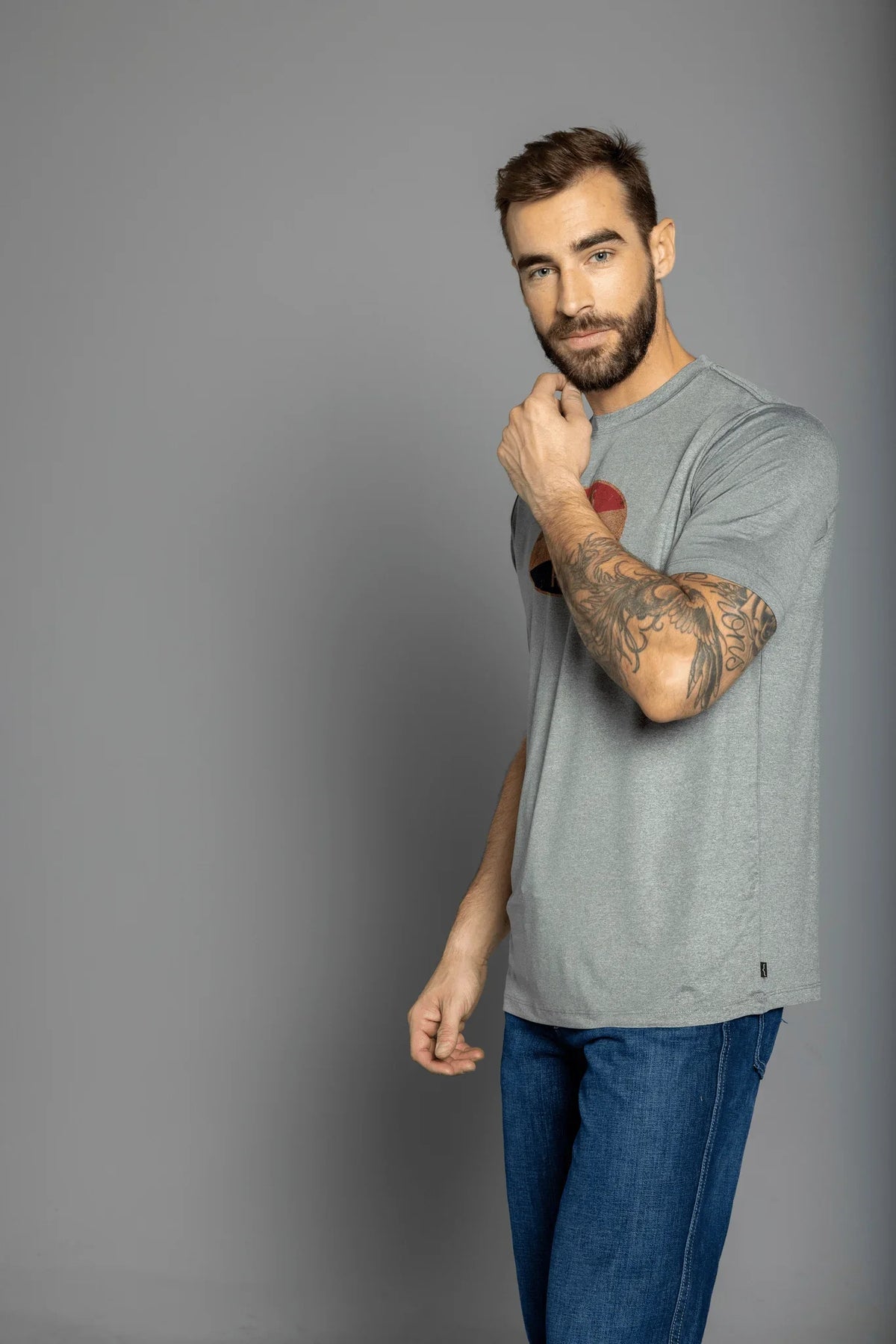 Kimes Ranch American Standard Tech T-Shirt in Athletic Grey Heather, side view, with a graphic print on the chest
