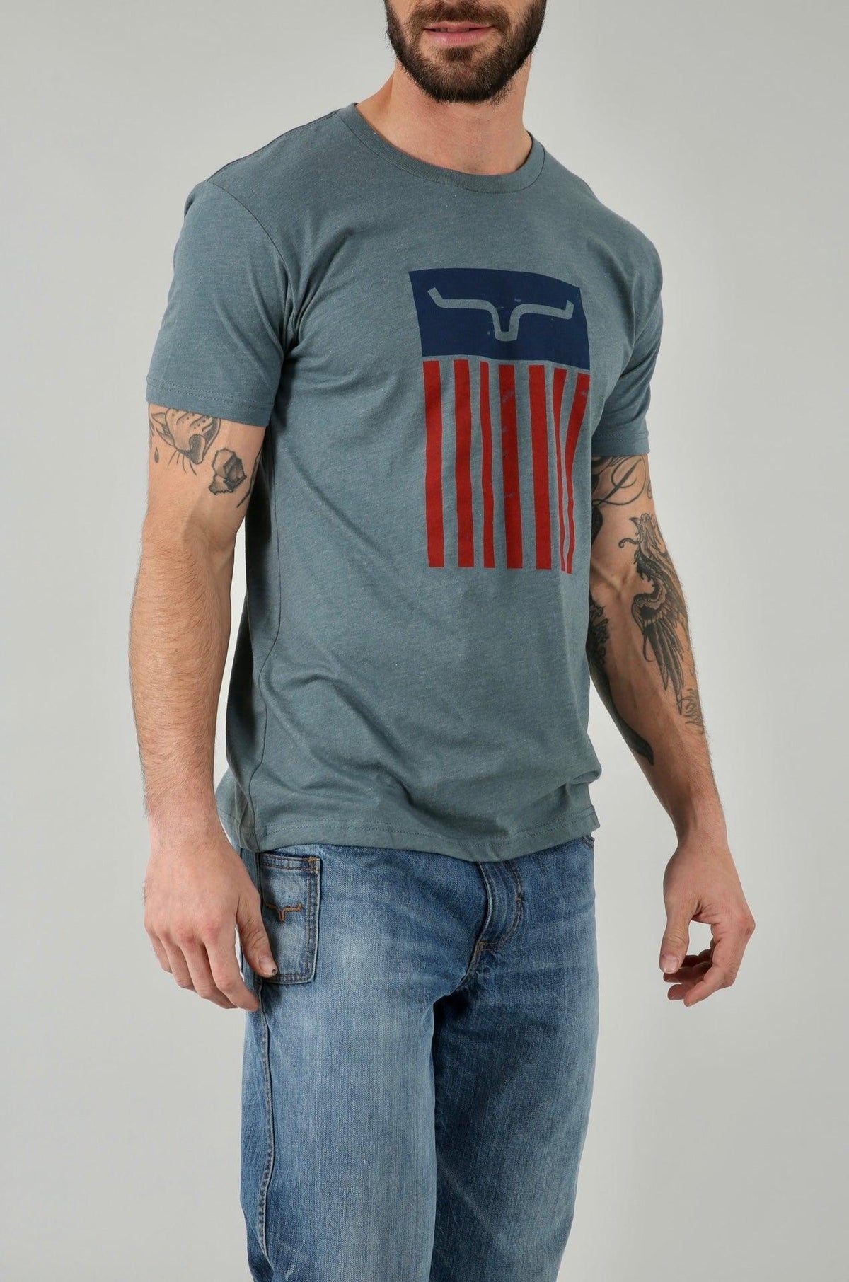 Kimes Ranch Cody Tee Shirt in heathered blue with a graphic of the Kimes Ranch logo over red and blue stripes