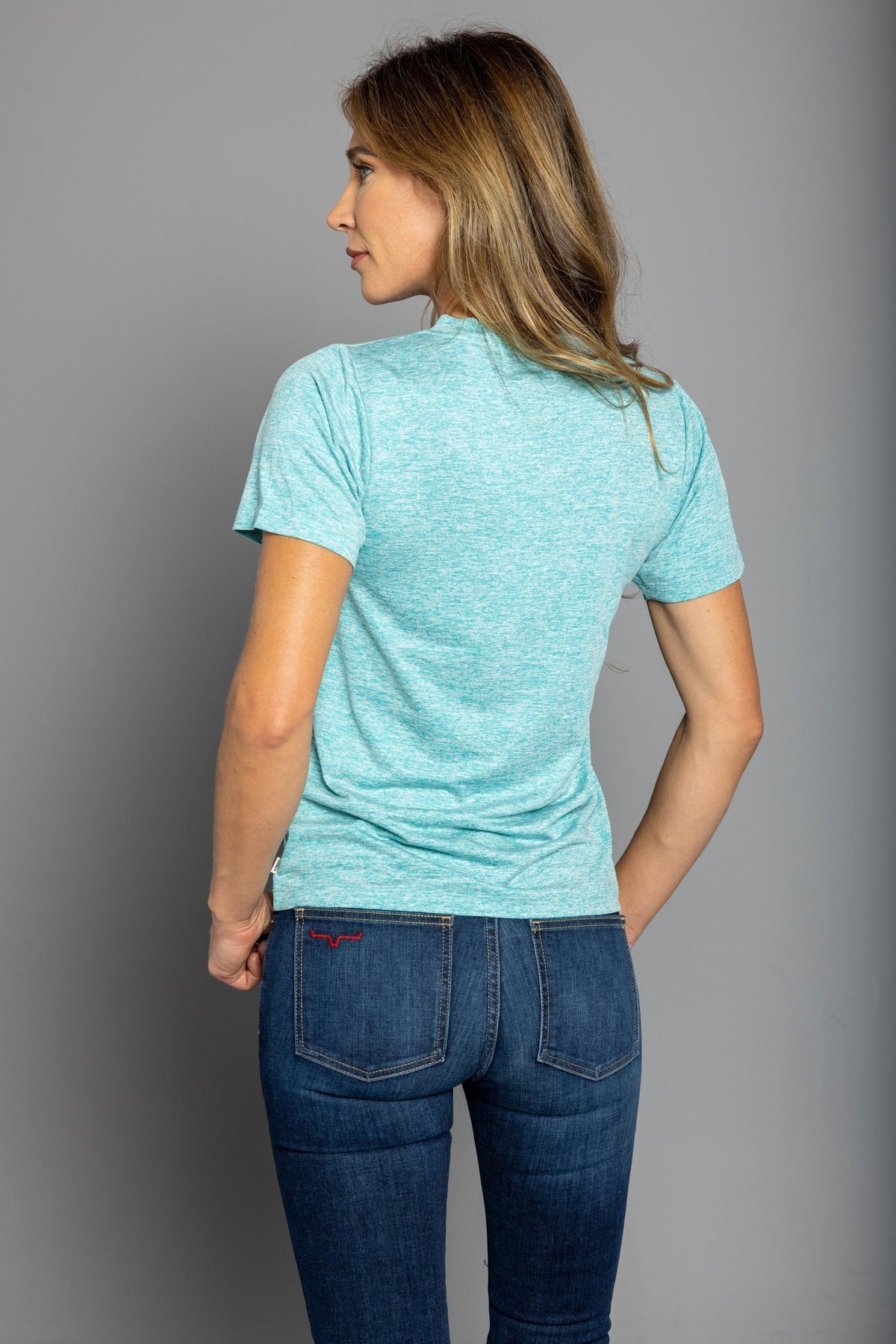 Kimes Ranch Ladies Outlier Tech Tee Shirt in Light Blue Heather, back view, with short sleeves and a relaxed fit