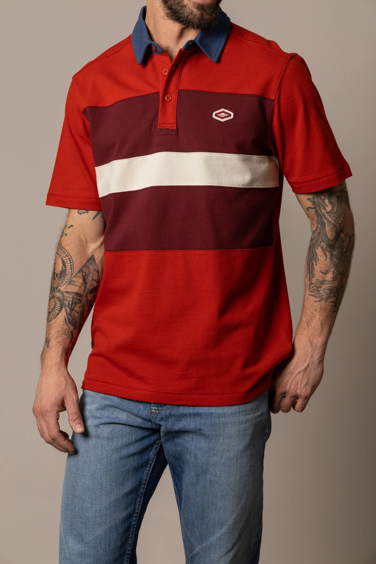 Kimes Ranch 1874 Polo in Brick Red with navy collar and horizontal burgundy and cream stripes with Kimes Ranch logo