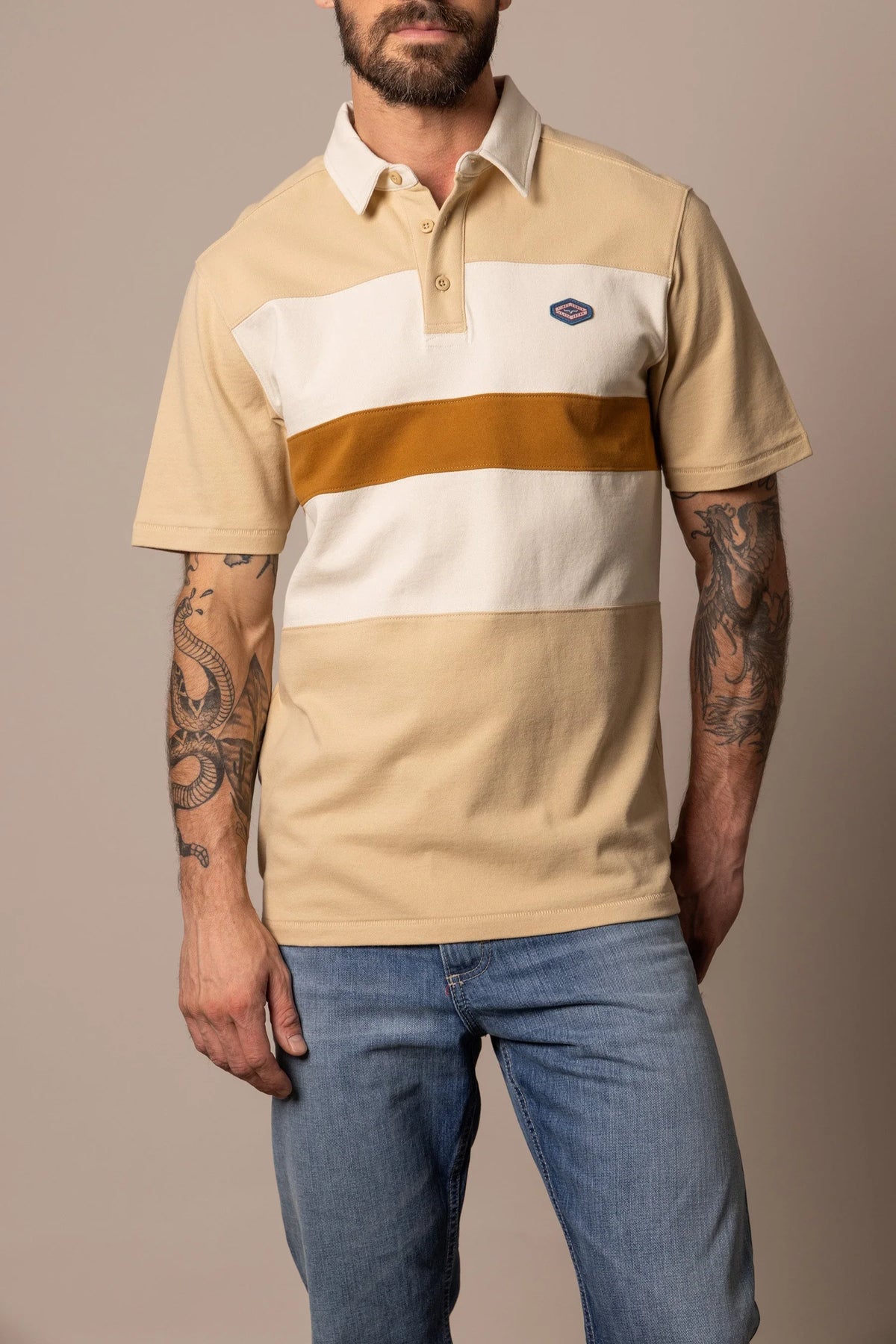 Kimes Ranch 1874 Polo in Tan with a white collar and a horizontal stripe pattern across the chest