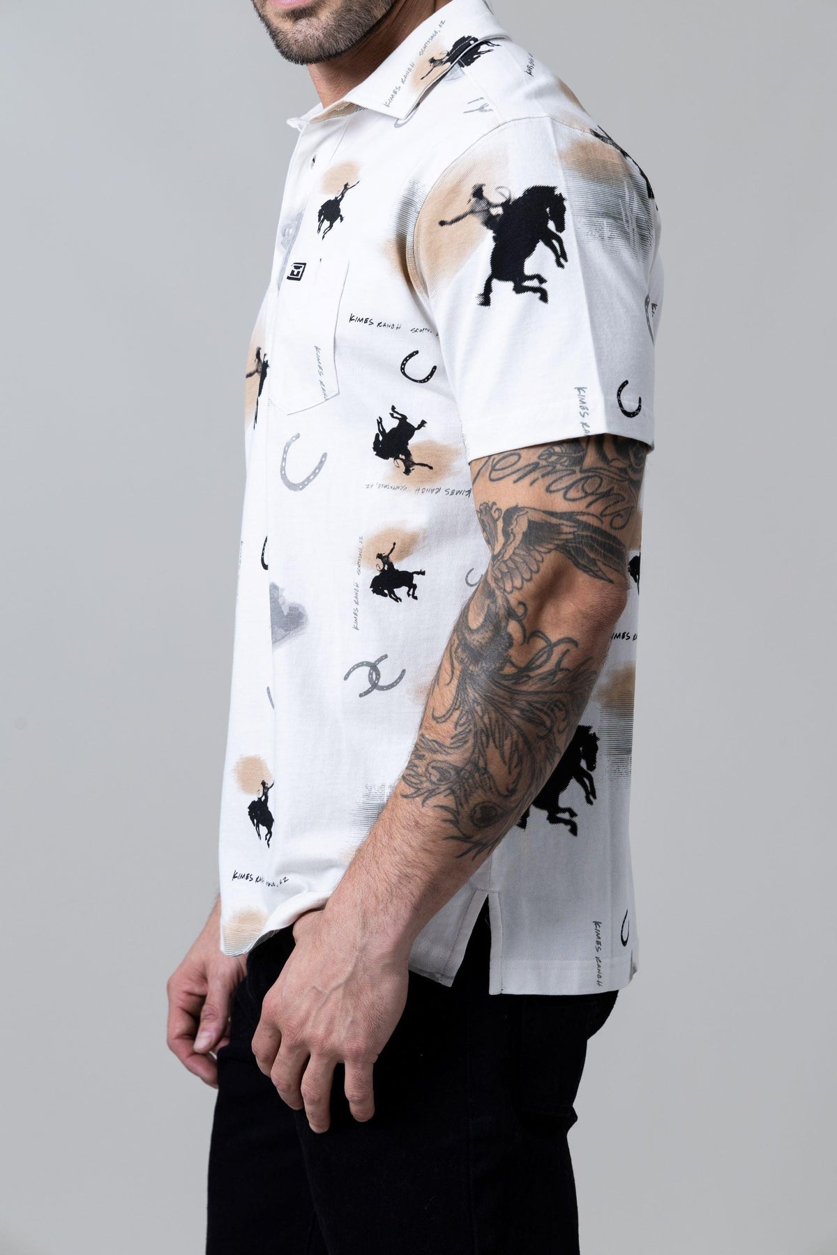 Kimes Ranch Bayard Polo in Light Grey, side view, with an all-over print of black rodeo silhouettes and horseshoes