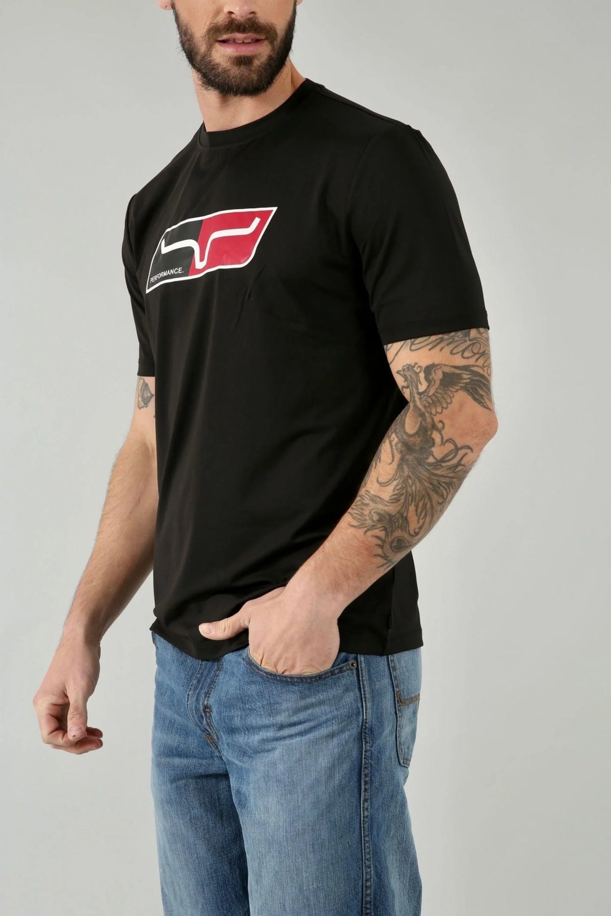 Kimes Ranch Alta Tech Tee Shirt in Black, side view, with a red and white Performance logo on the chest