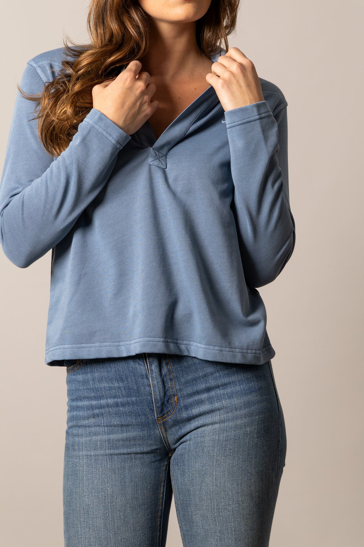 Kimes Ranch Abby top in Mid Blue with a long sleeve henley neckline and a small logo on the chest