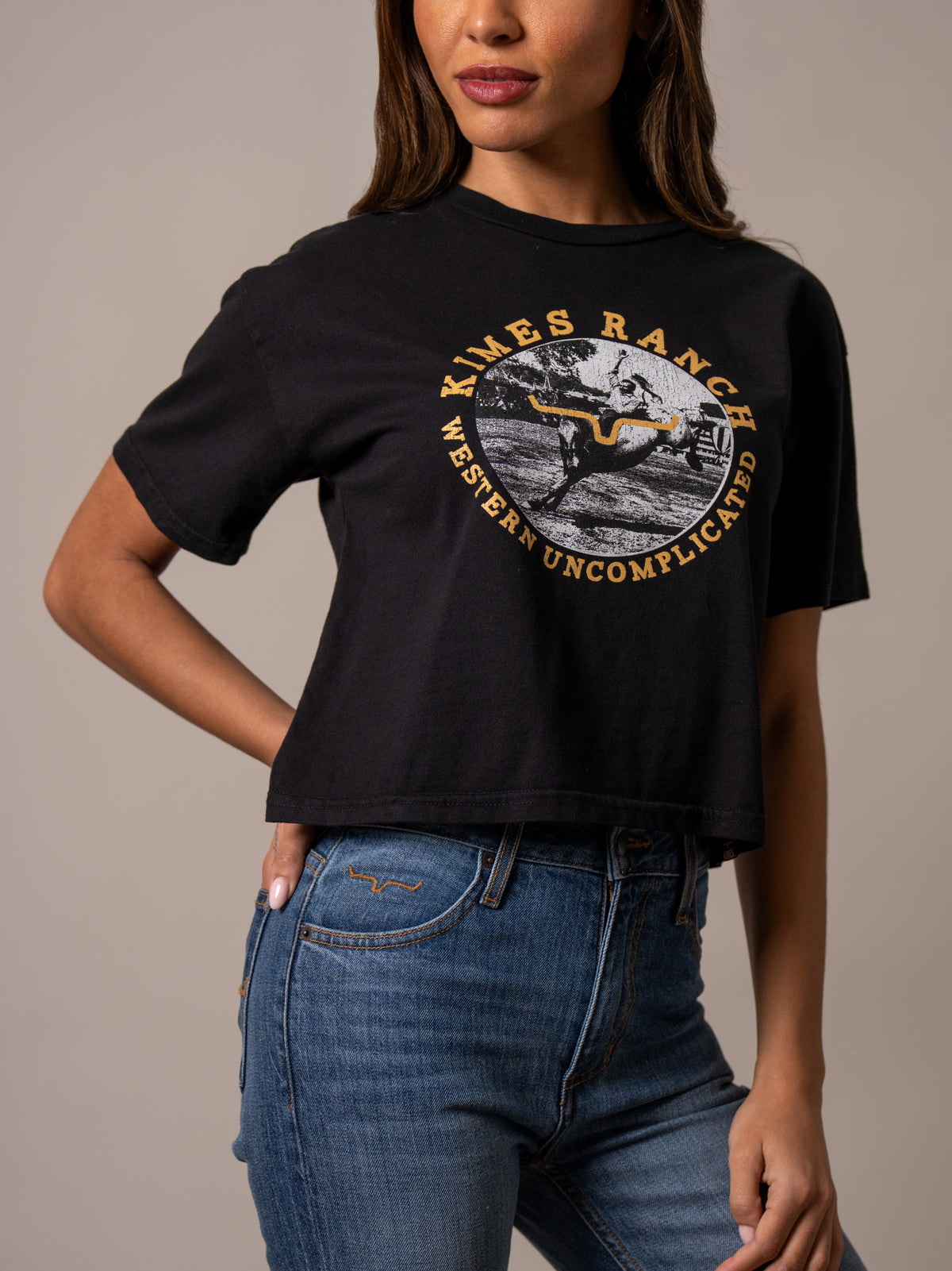 Kimes Ranch Afternoon Rodeo shirt with a circular graphic of a cowboy on a bucking horse and the text Western Uncomplicated