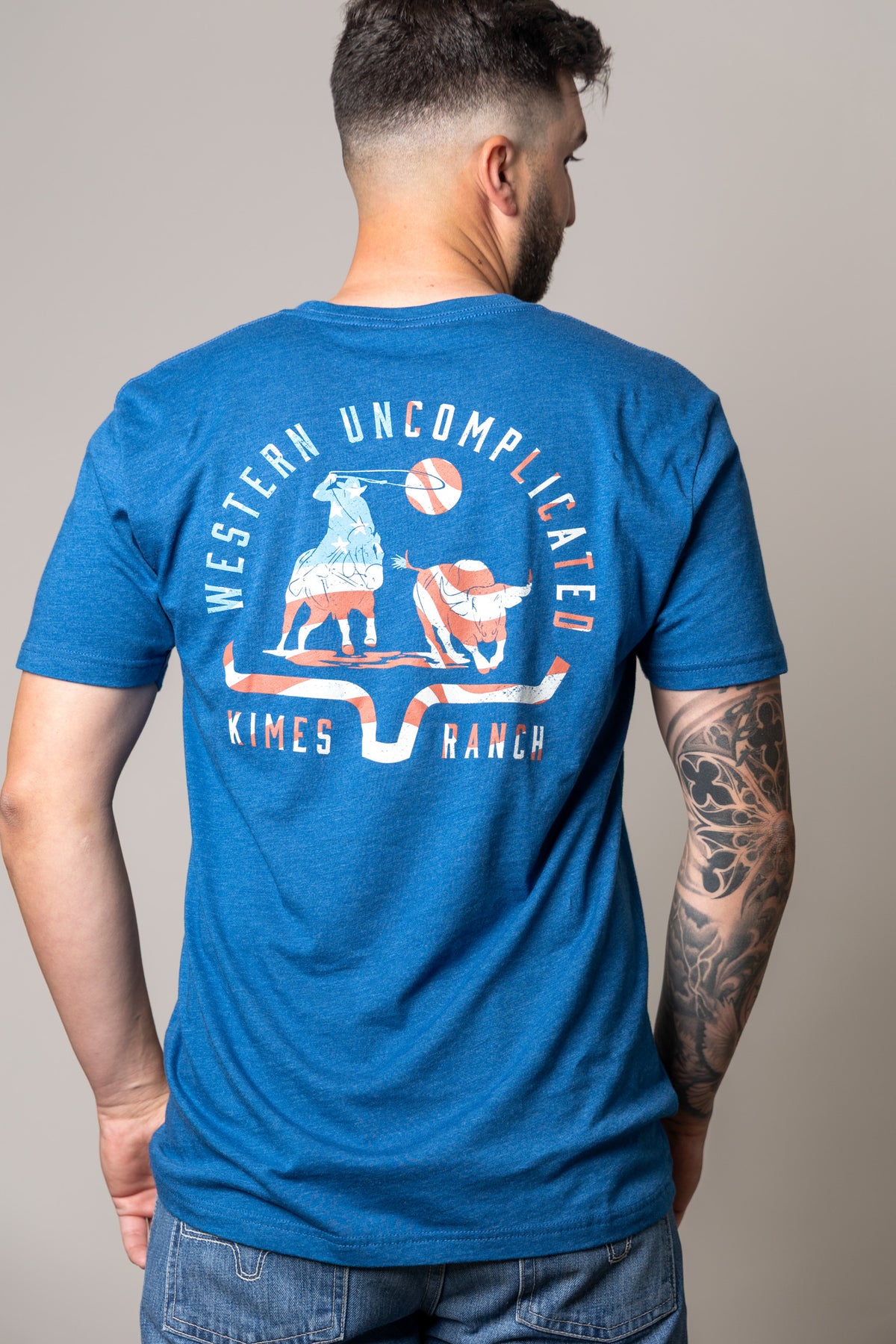 Kimes Ranch American Cowboy shirt in Heather Cool Blue, back view, with Western Uncomplicated graphic