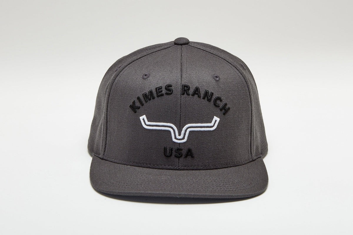 Kimes Ranch Arched Trucker Hat in Charcoal with the Kimes Ranch logo embroidered on the front