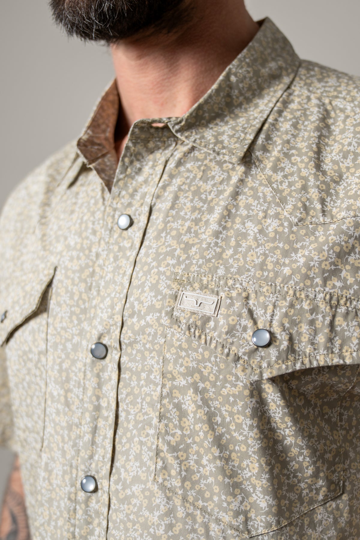 Kimes Ranch Bascom dress shirt in Sage, close-up, with a floral print, snap front, and chest pockets