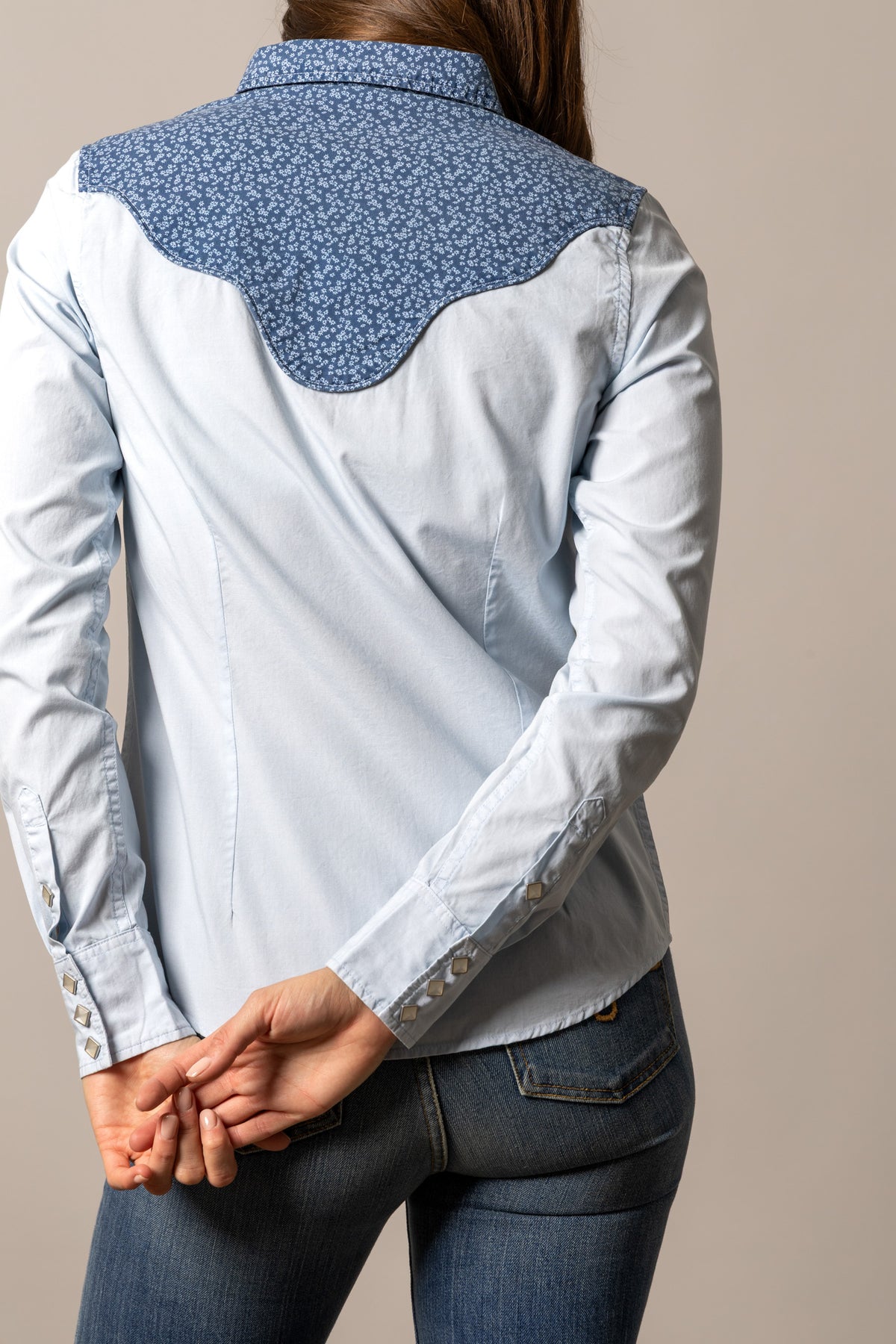 Kimes Ranch Birdie top in Light Blue, back view, with a floral back yoke and buttoned cuffs