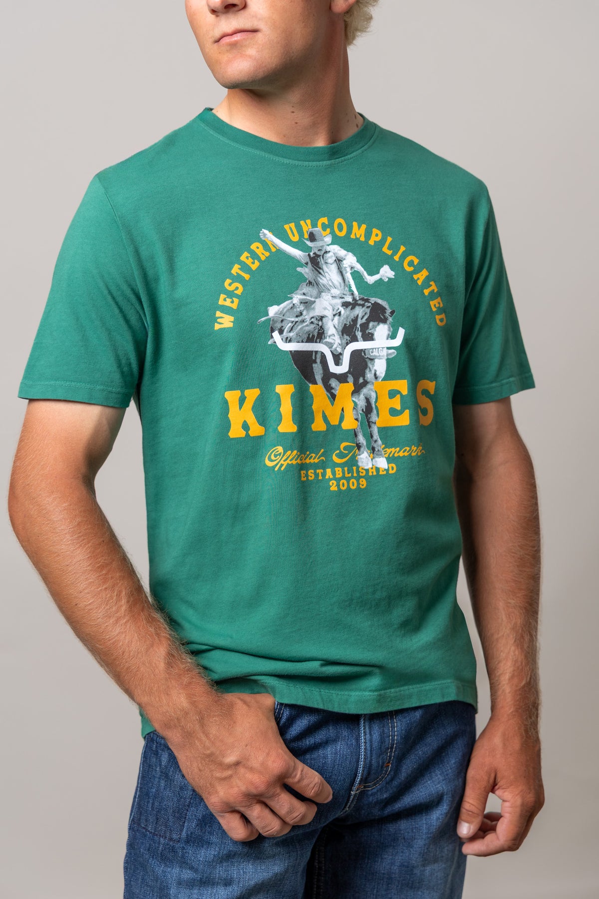 Kimes Ranch Break Through shirt in Green with a graphic of a cowboy riding a steer and the text Western Uncomplicated Kimes