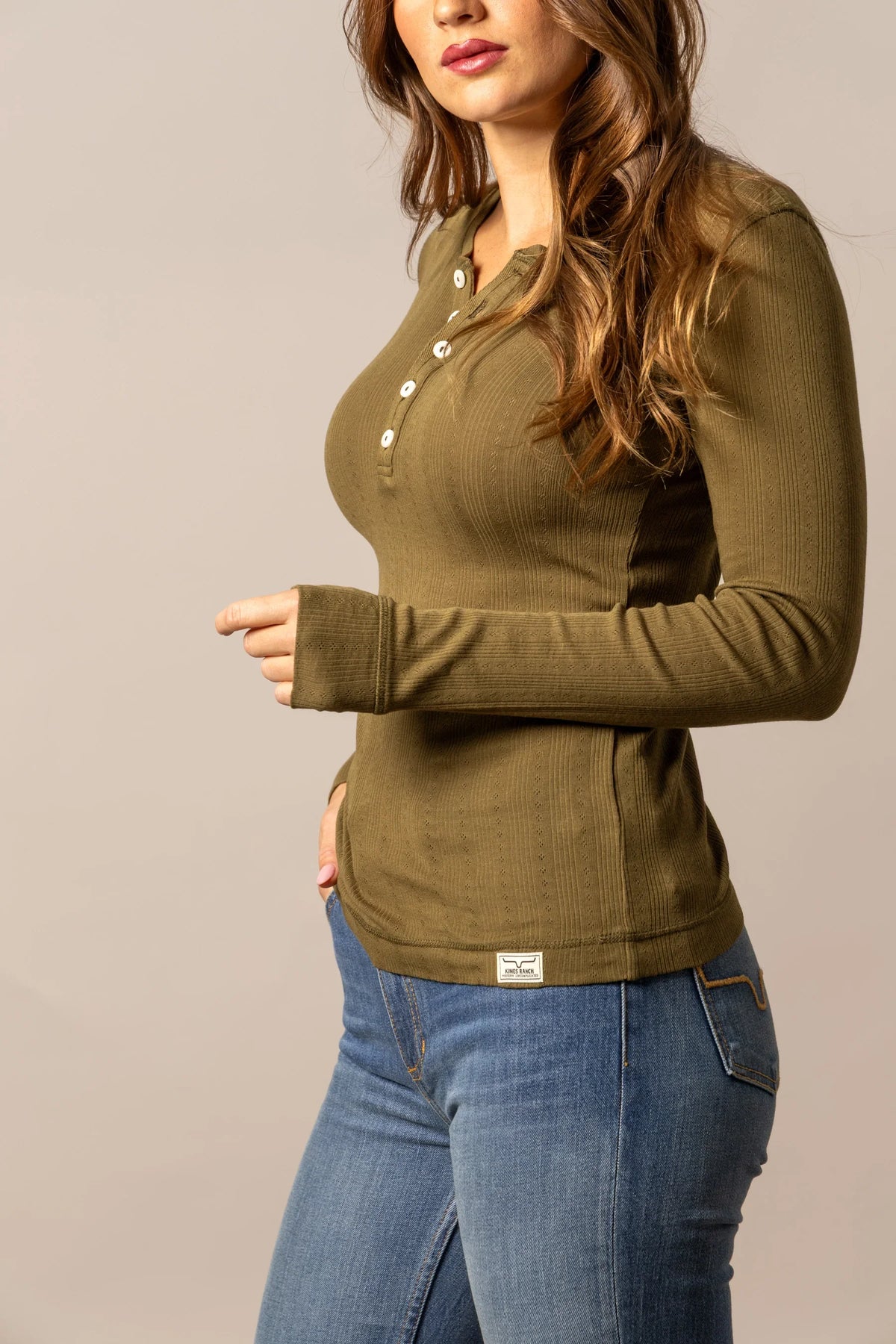 Kimes Ranch Bree Henley in Dark Olive, side view, with long sleeves and a button placket