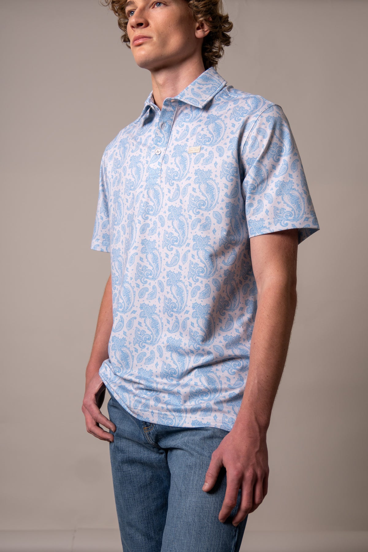 Kimes Ranch Burel polo in Blue, side view, with an all-over paisley print and a chest logo