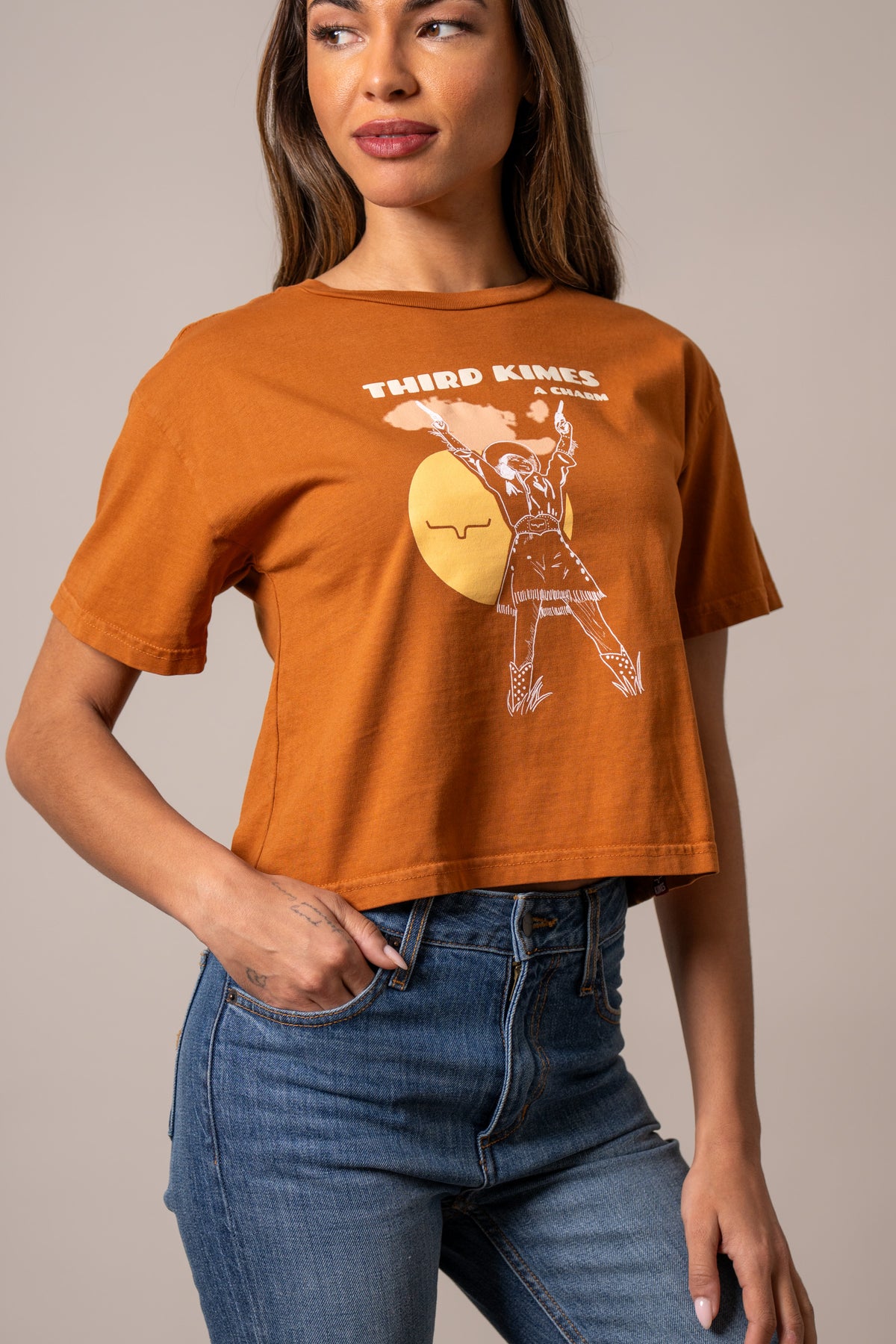 Kimes Ranch Charming shirt in Rust with a graphic of a dancing figure and the text THIRD KIMES A CHARM