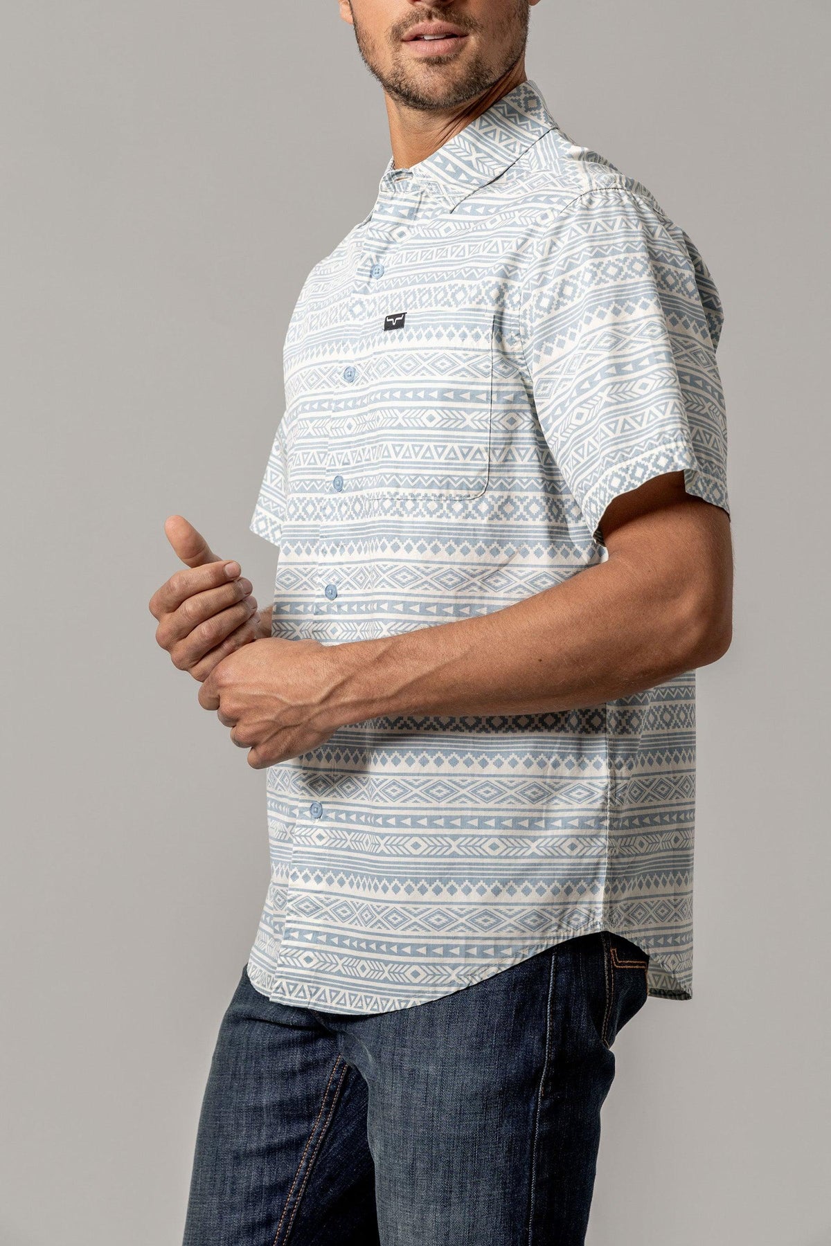 Kimes Ranch Colton short sleeve dress shirt in Light Blue, side view, with a geometric pattern and a chest pocket