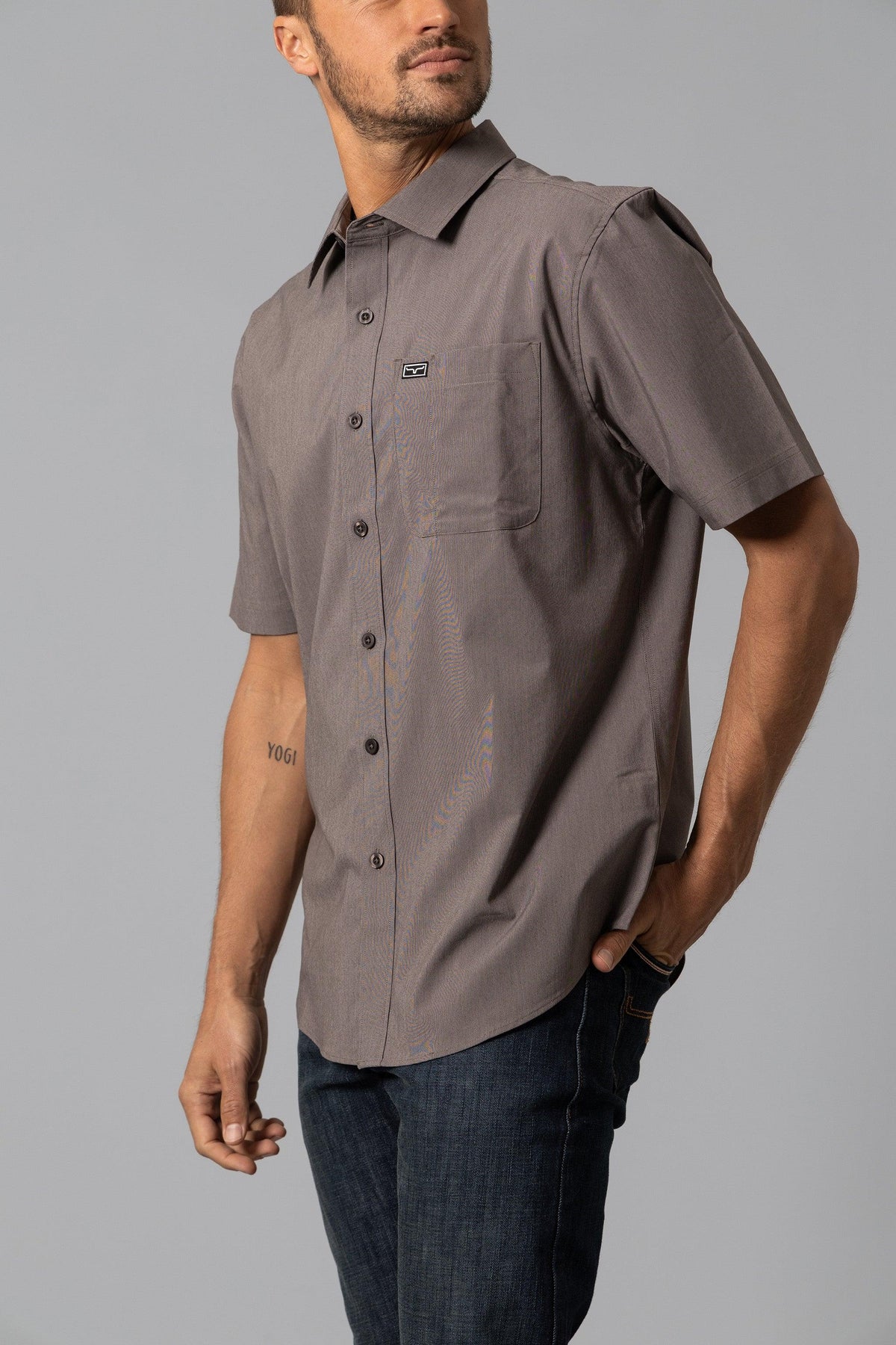 Kimes Ranch Linville Short Sleeve Dress Shirt in Brown, side view, with a chest pocket and logo patch
