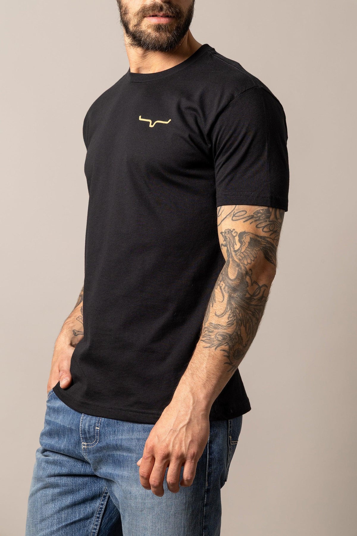 Kimes Ranch Desert Diamond, side view, Black shirt with short sleeves and a gold Kimes Ranch logo on the chest