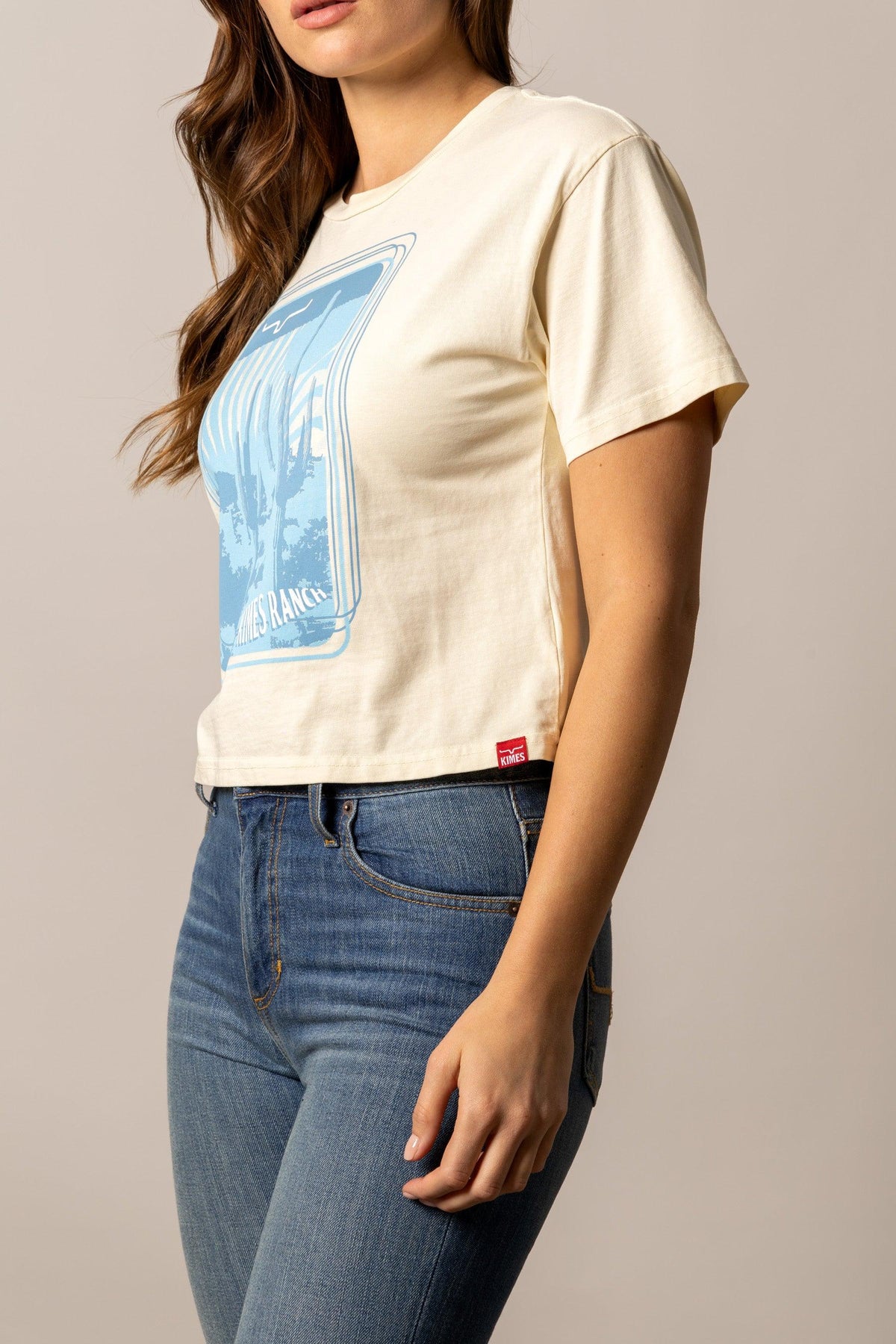 Kimes Ranch Desert Trip shirt in Ivory, side view, with a blue graphic print and Kimes Ranch logo