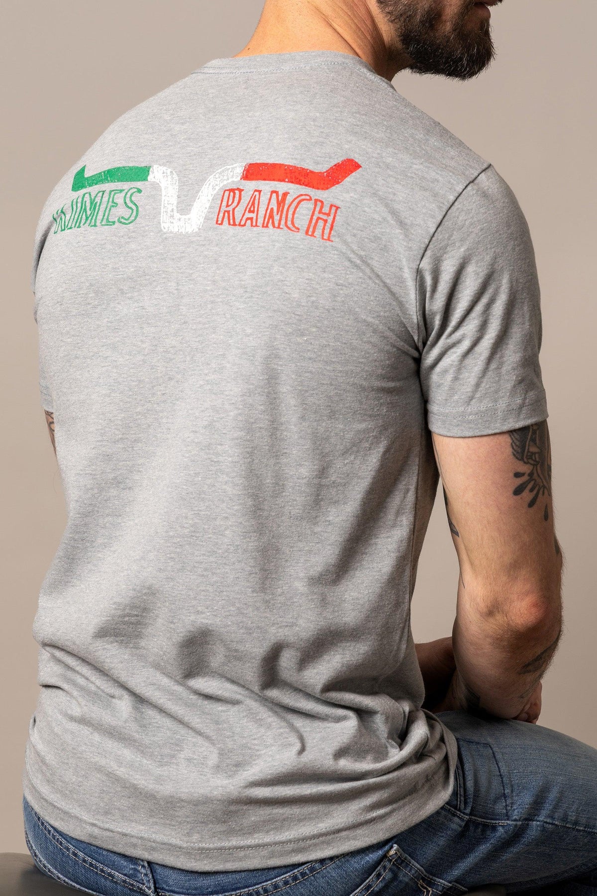 Kimes Ranch Dibujada shirt in Dark Grey Heather, back view, with back graphic featuring Kimes Ranch logo and green