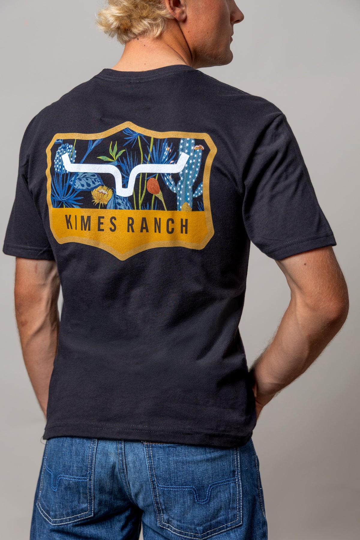 Kimes Ranch Dillard Floral shirt in Black, back view, with a back graphic of blue cacti and a Kimes Ranch logo