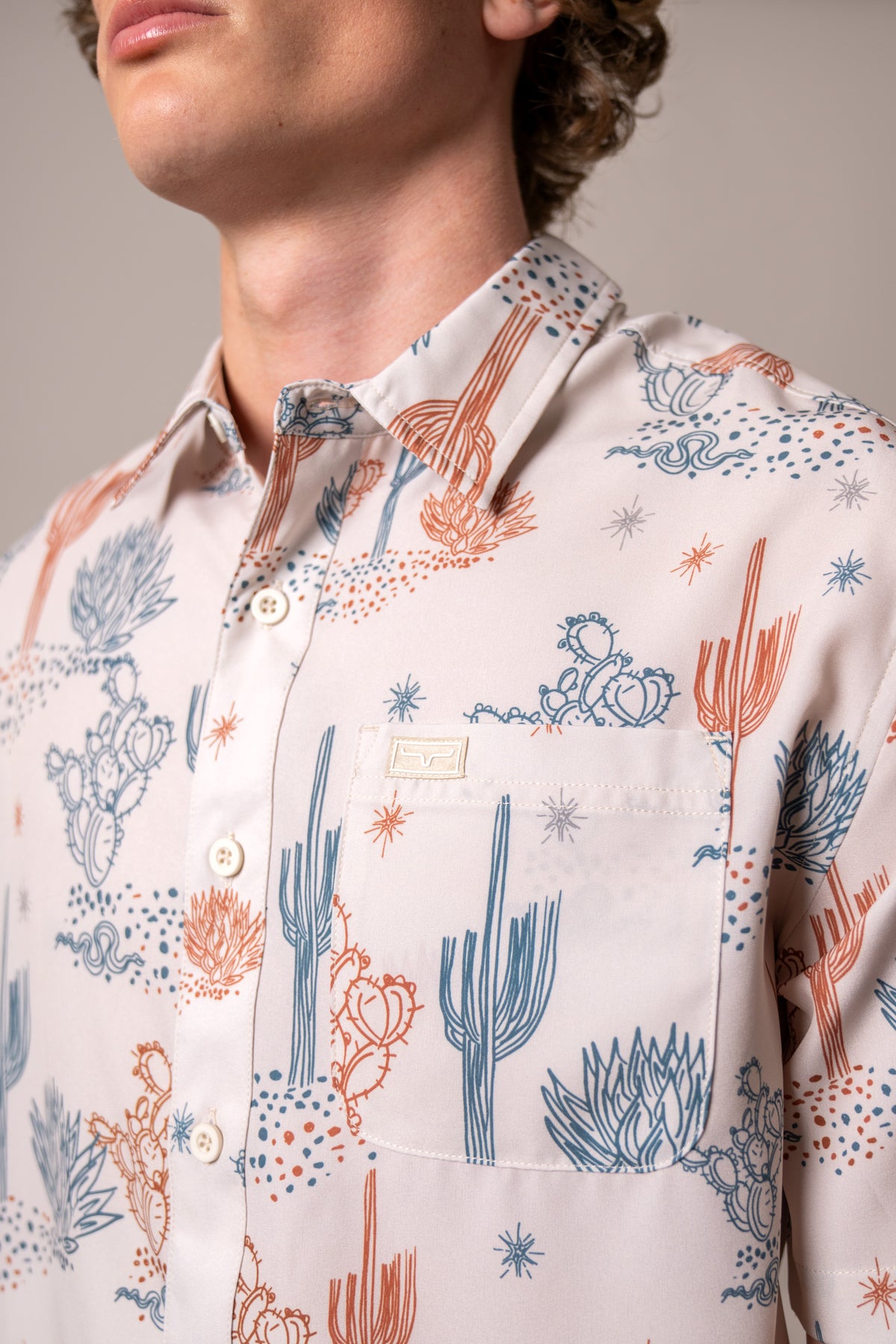 Kimes Ranch Dunn dress shirt in Natural, close-up, with a desert print of blue and orange cacti and a chest pocket