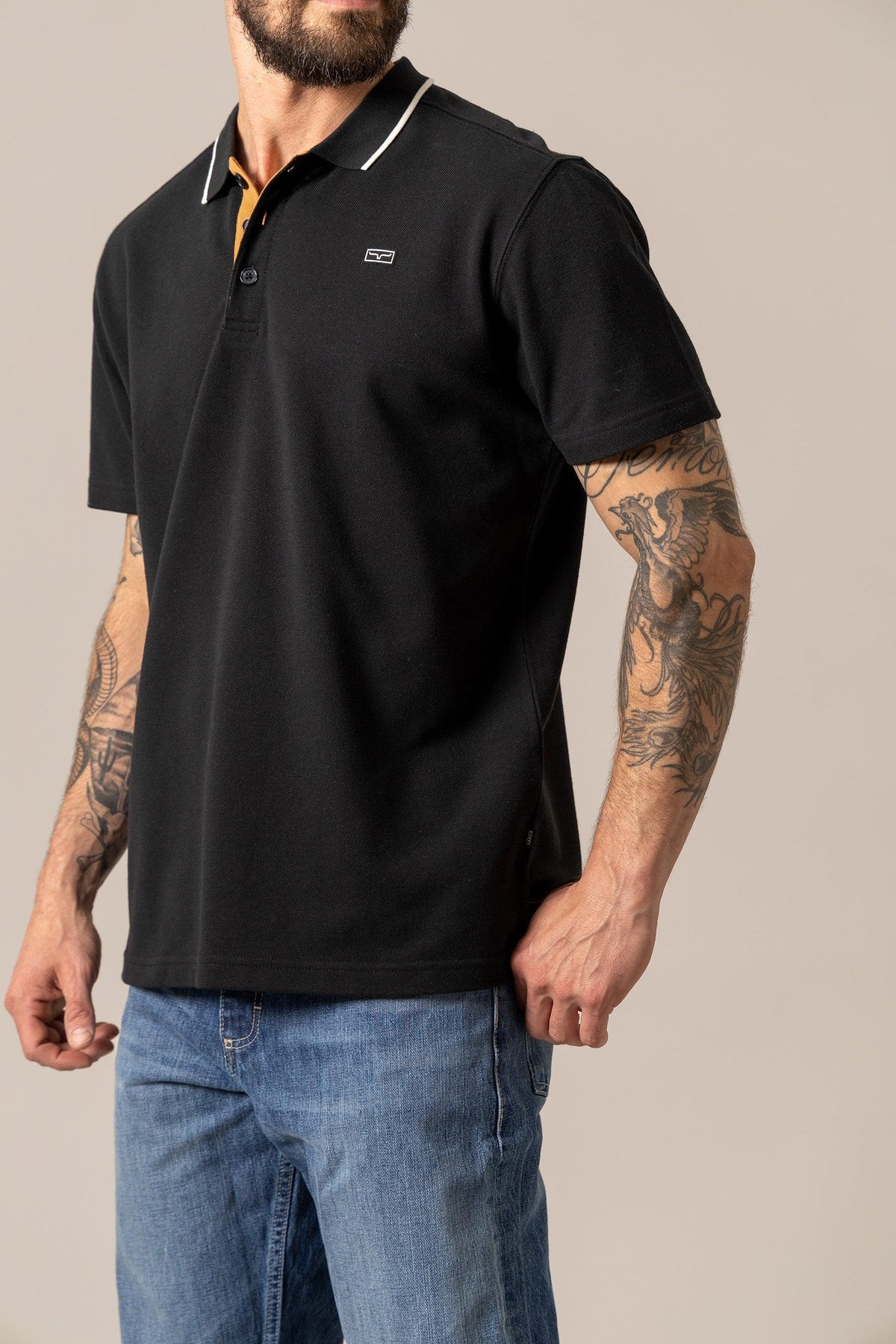 Kimes Ranch El Capitan Polo in Black, side view, with white collar trim and embroidered logo