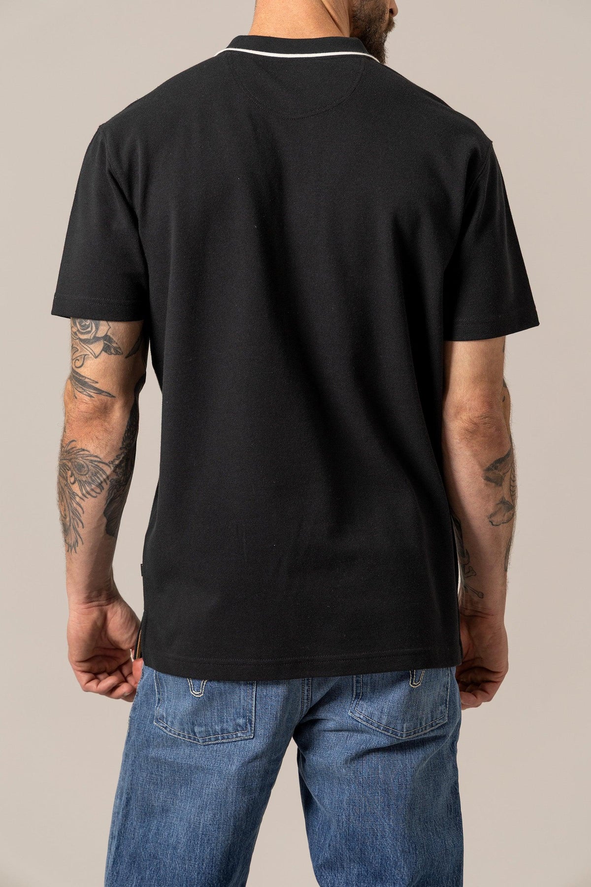 Kimes Ranch El Capitan Polo in Black, back view, with a white contrast collar and short sleeves