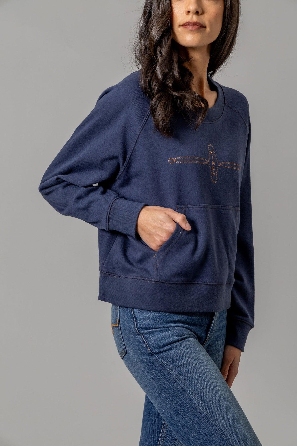 Kimes Ranch Gracie Cropped Crewneck sweatshirt in Blue, side view, with a front kangaroo pocket and embroidered logo