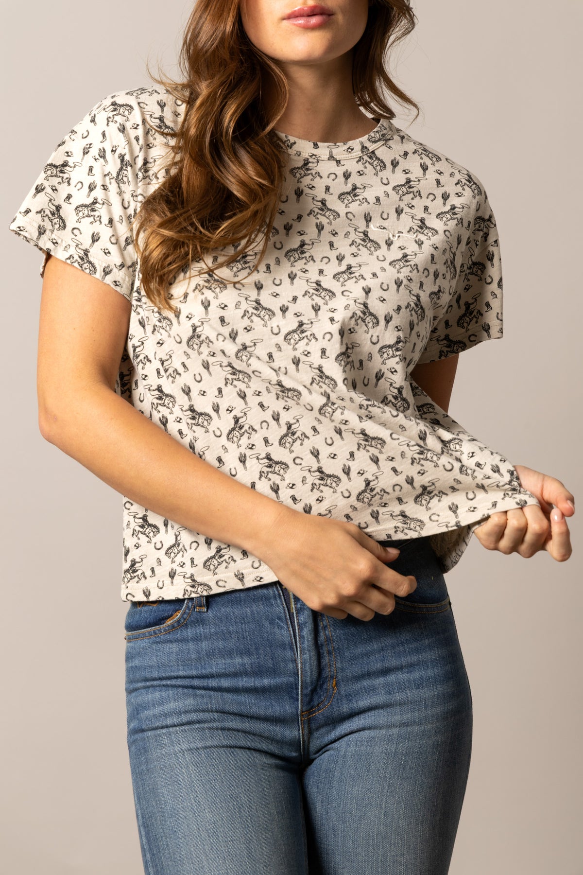 Kimes Ranch Hayloft shirt in Bone with a repeating print of cowboys on horseback and horseshoes