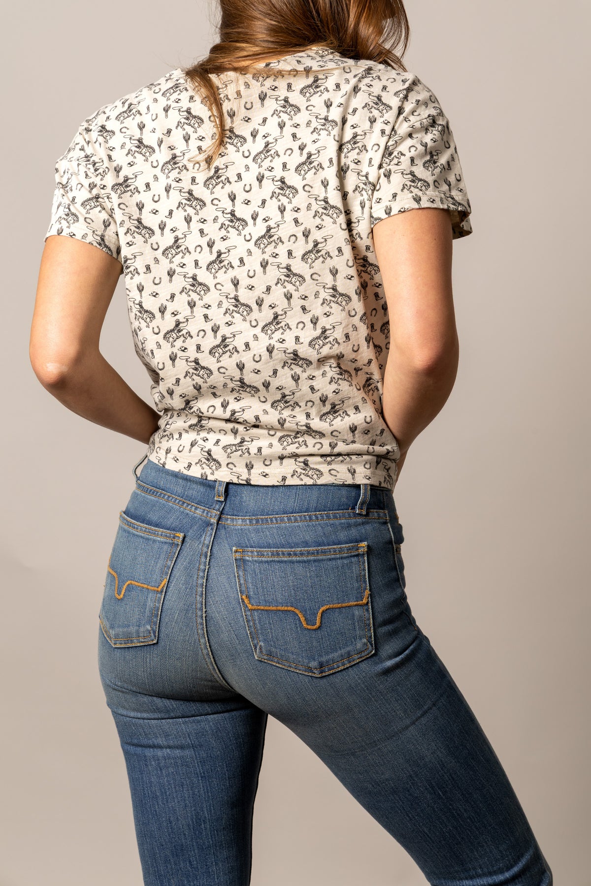 Kimes Ranch Hayloft shirt in Bone, back view, with a western print of cowboys and cacti