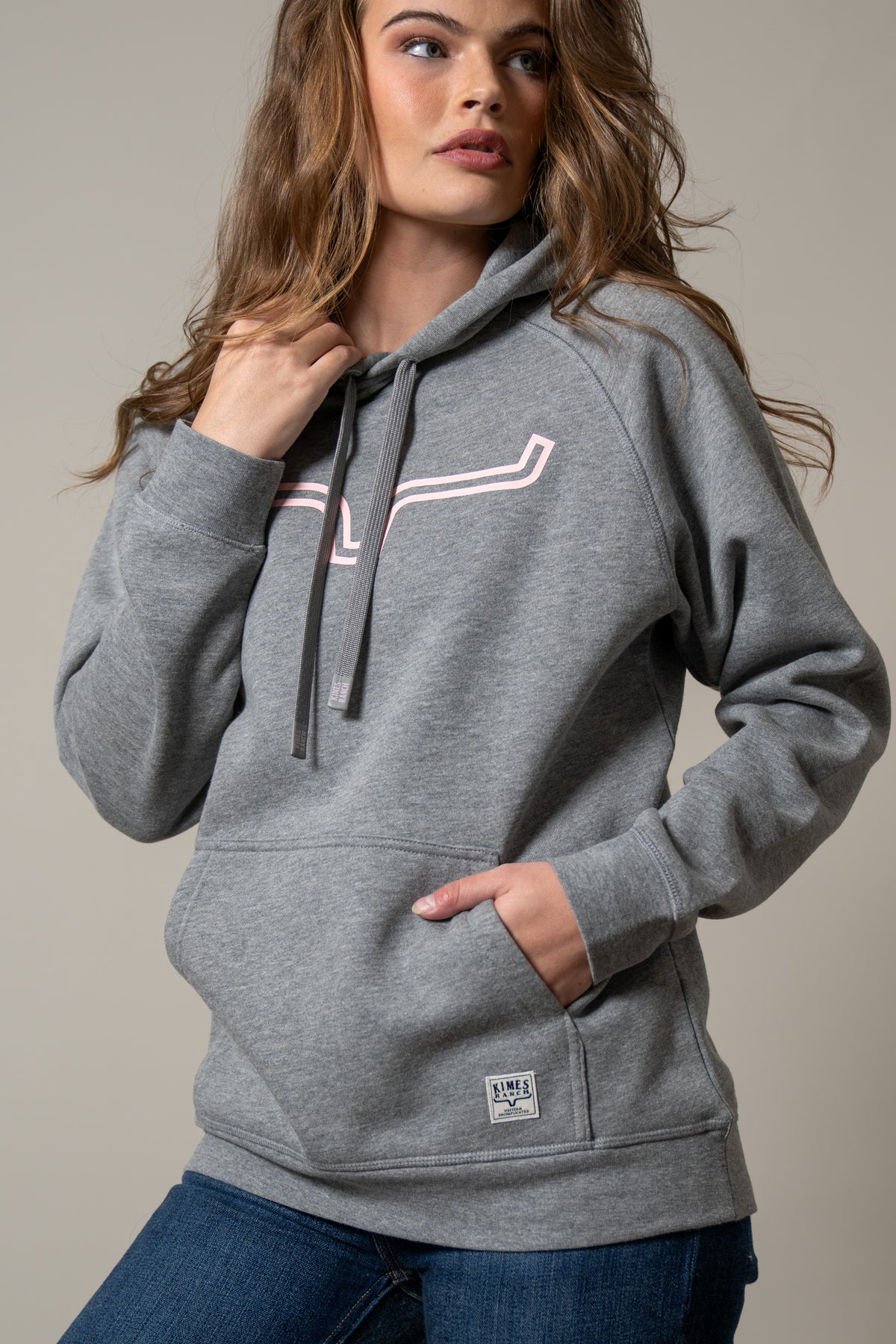Kimes Ranch Ladies Outlier Hoodie in Grey Heather with a pink graphic and front pocket