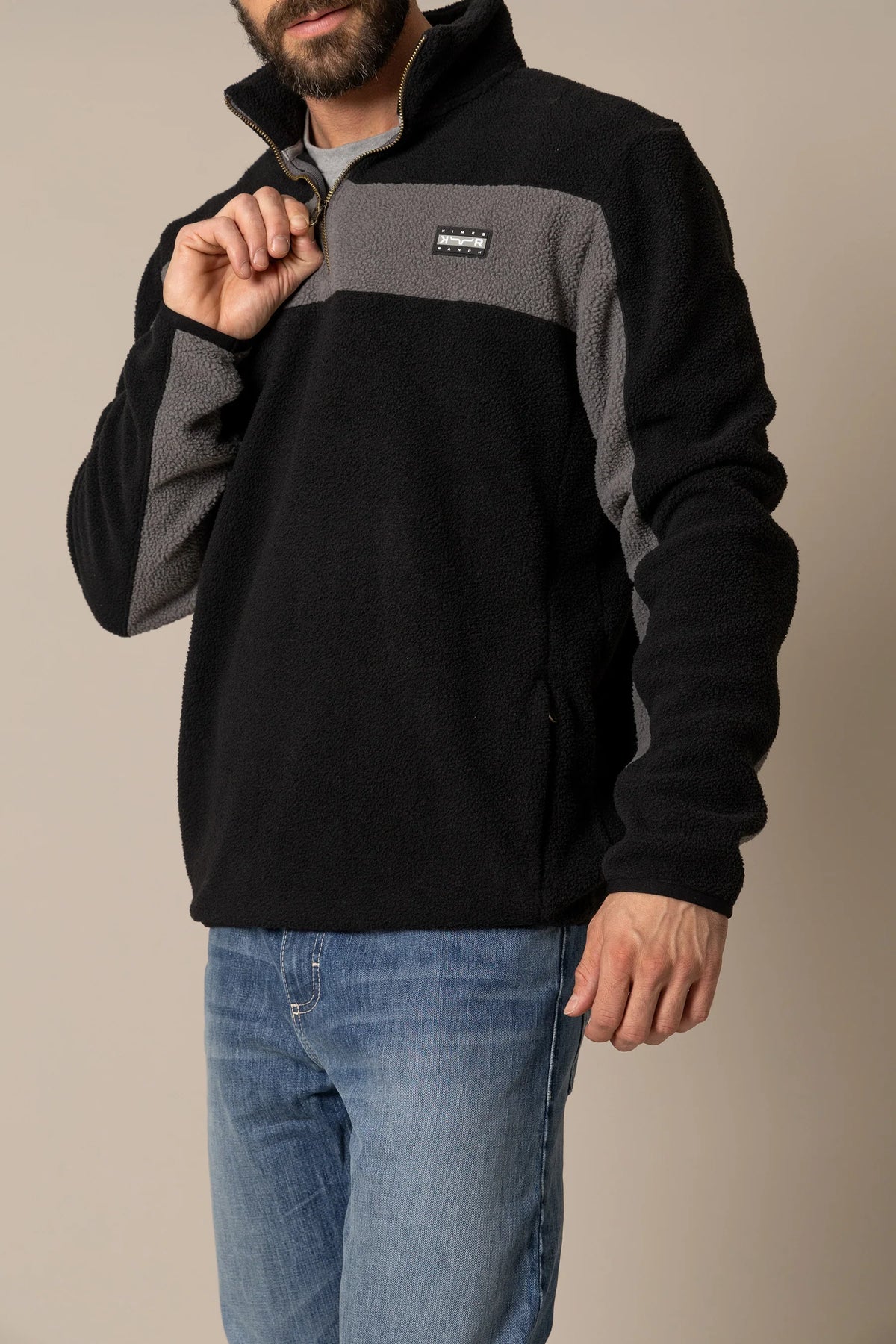 Kimes Ranch JMJ Quarter Zip sweatshirt in Black with grey paneling and the Kimes Ranch logo on the chest