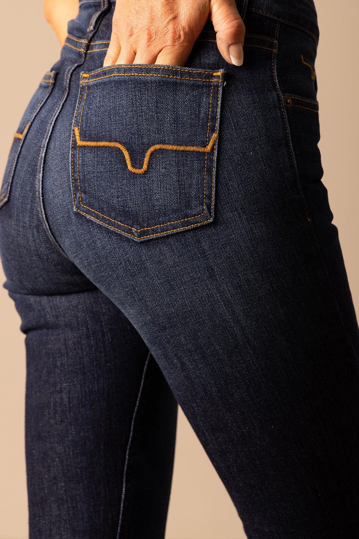 Kimes Ranch Jennifer jeans in Dark Wash with a close-up of the back pocket featuring signature orange stitching
