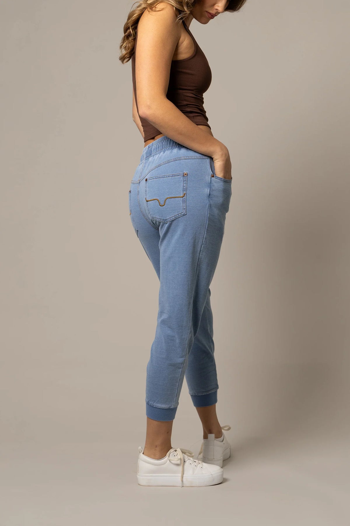 Kimes Ranch Joanie pants in Light Wash Indigo, side view, with the back pocket and tapered leg
