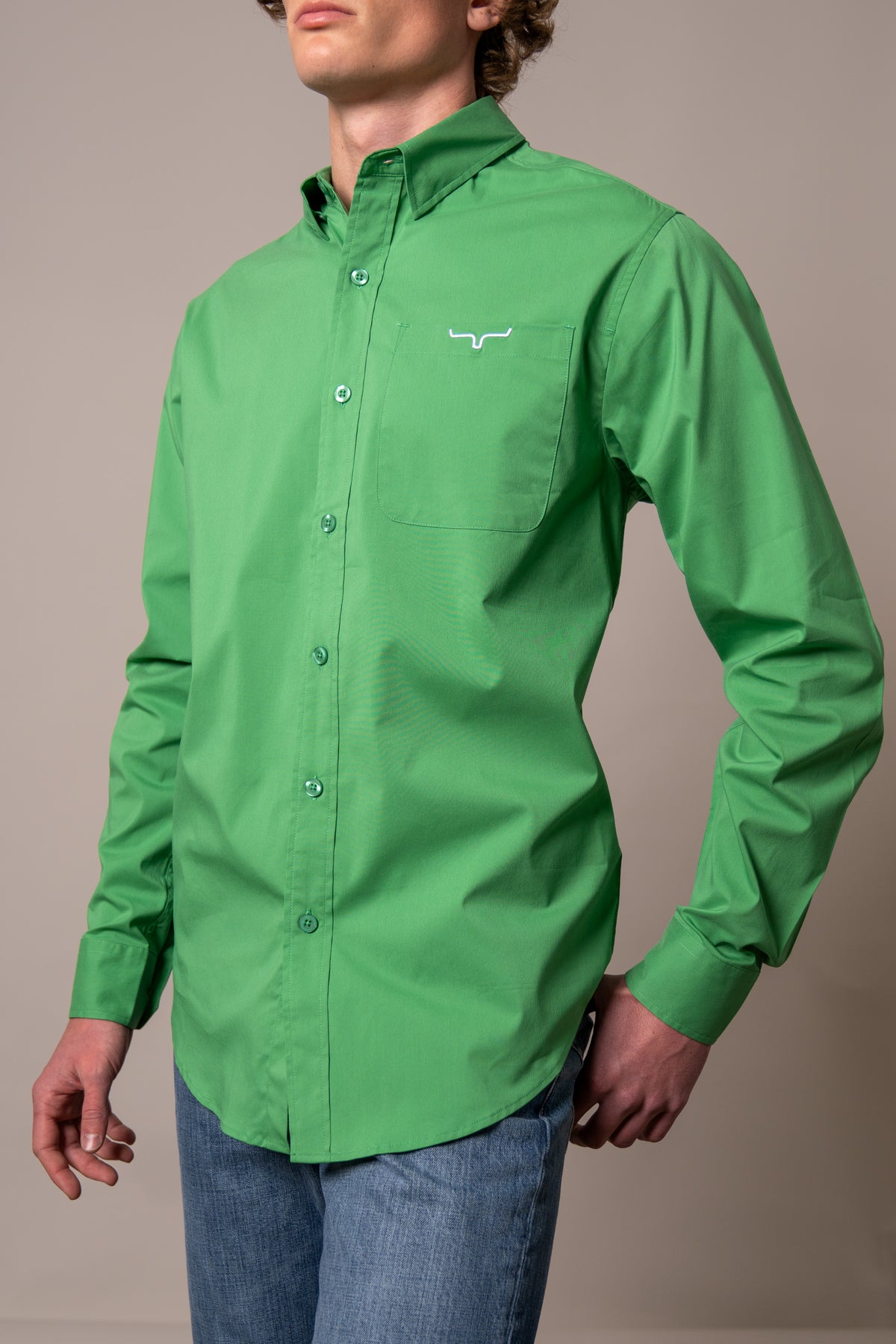 Kimes Ranch KR Team Dress Shirt in Kelly Green, side view, with a button front and chest pocket with the Kimes Ranch logo