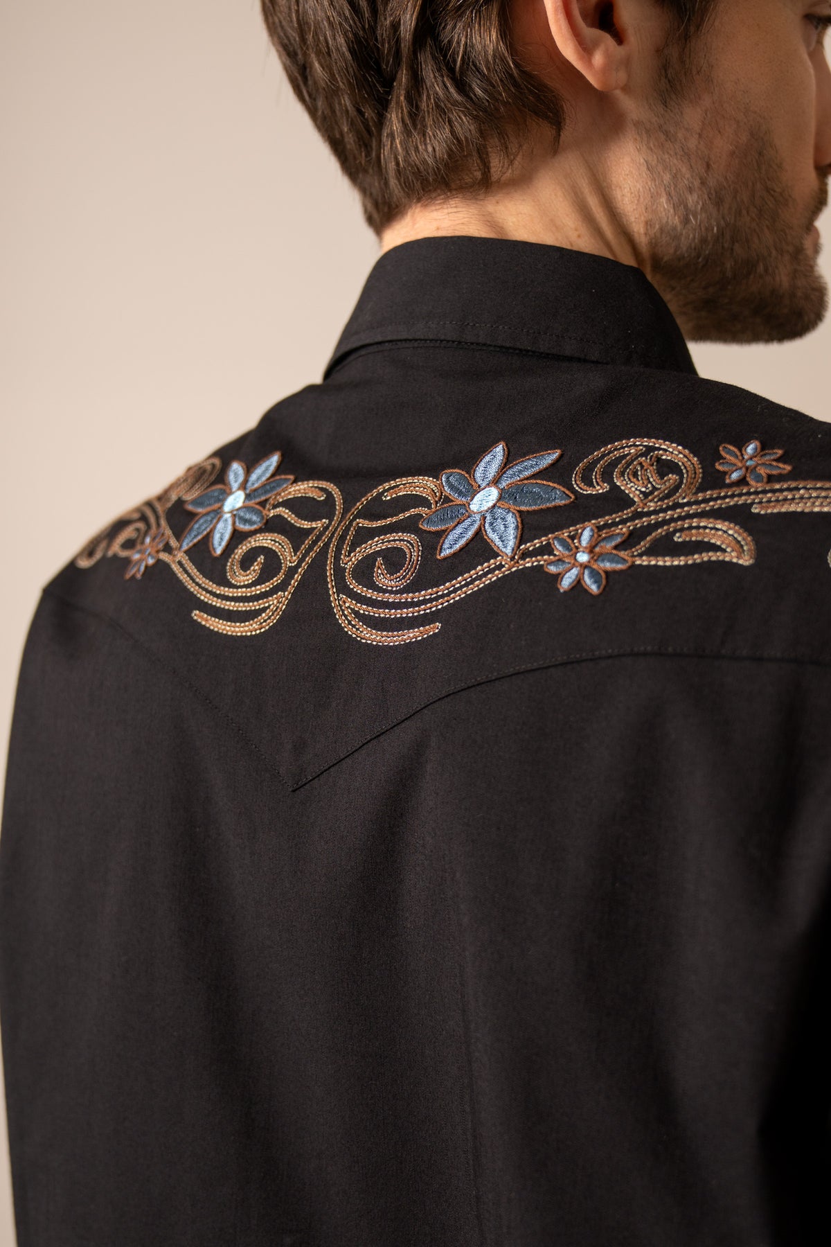 Kimes Ranch Leland, back view, Black dress shirt with blue and tan floral embroidery on the yoke