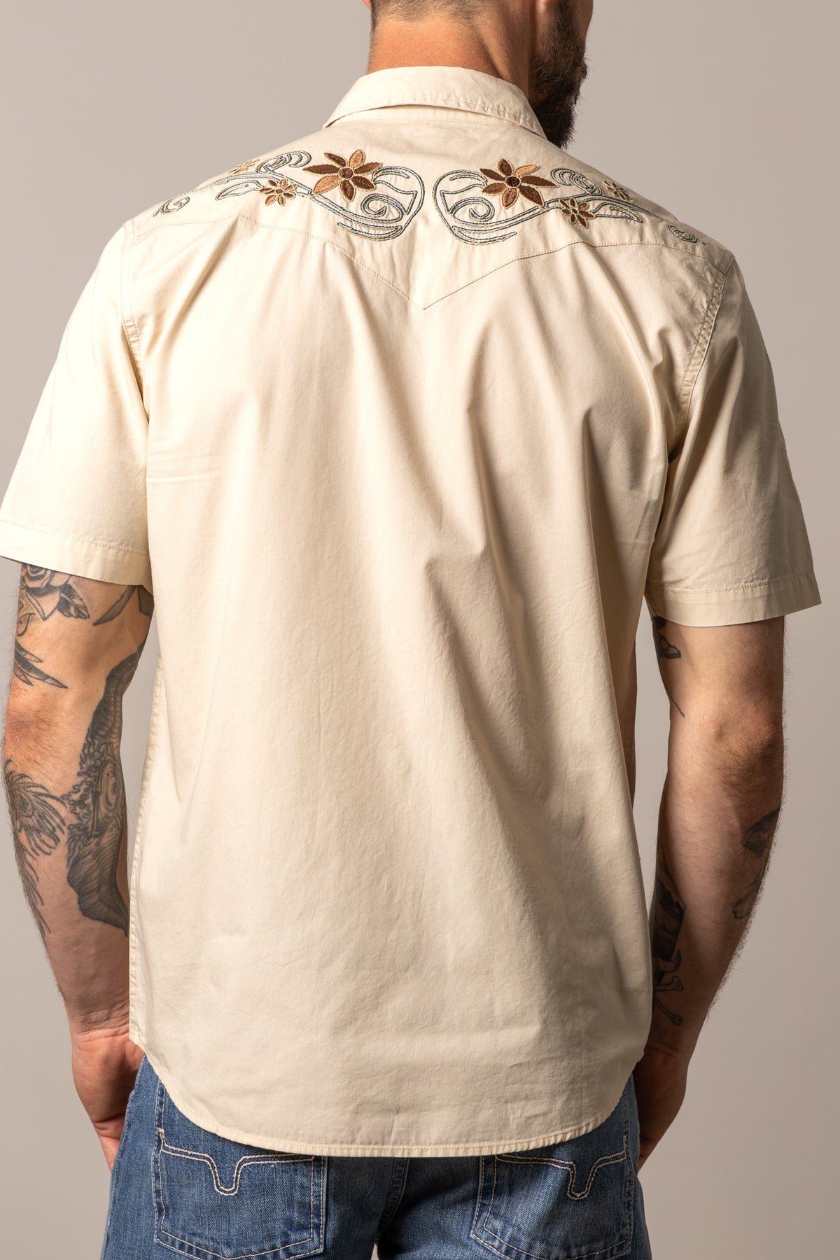 Kimes Ranch Leland short sleeve dress shirt in Natural, back view, with floral embroidery on the back yoke